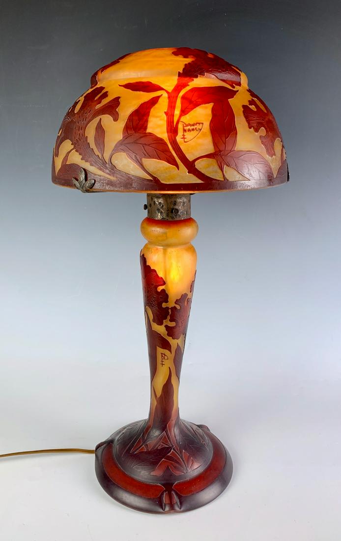 Signed Daum Nancy Cameo Glass Lamp C. 1900: Amber and red colored celosia cristata flowers and leaves table lamp, both shade and base signed "Daum Nancy" with cross of Lorraine, both shade and base light up, very good condition, 18" height, 9.2