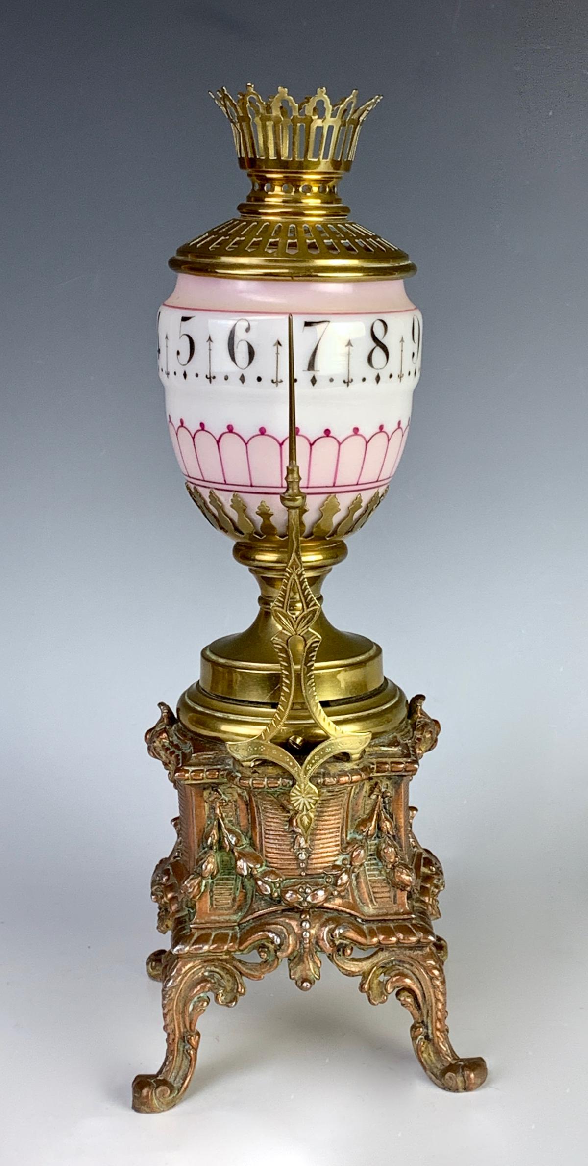 Rare Gilt & Patinated Metal Annular Candle Clock: Circa 1880, French rotating glass globe in white opaline, mounted above a gilt and patinated metal ornate base which contains clock mechanism and scroll feet, good condition, not in running condition,