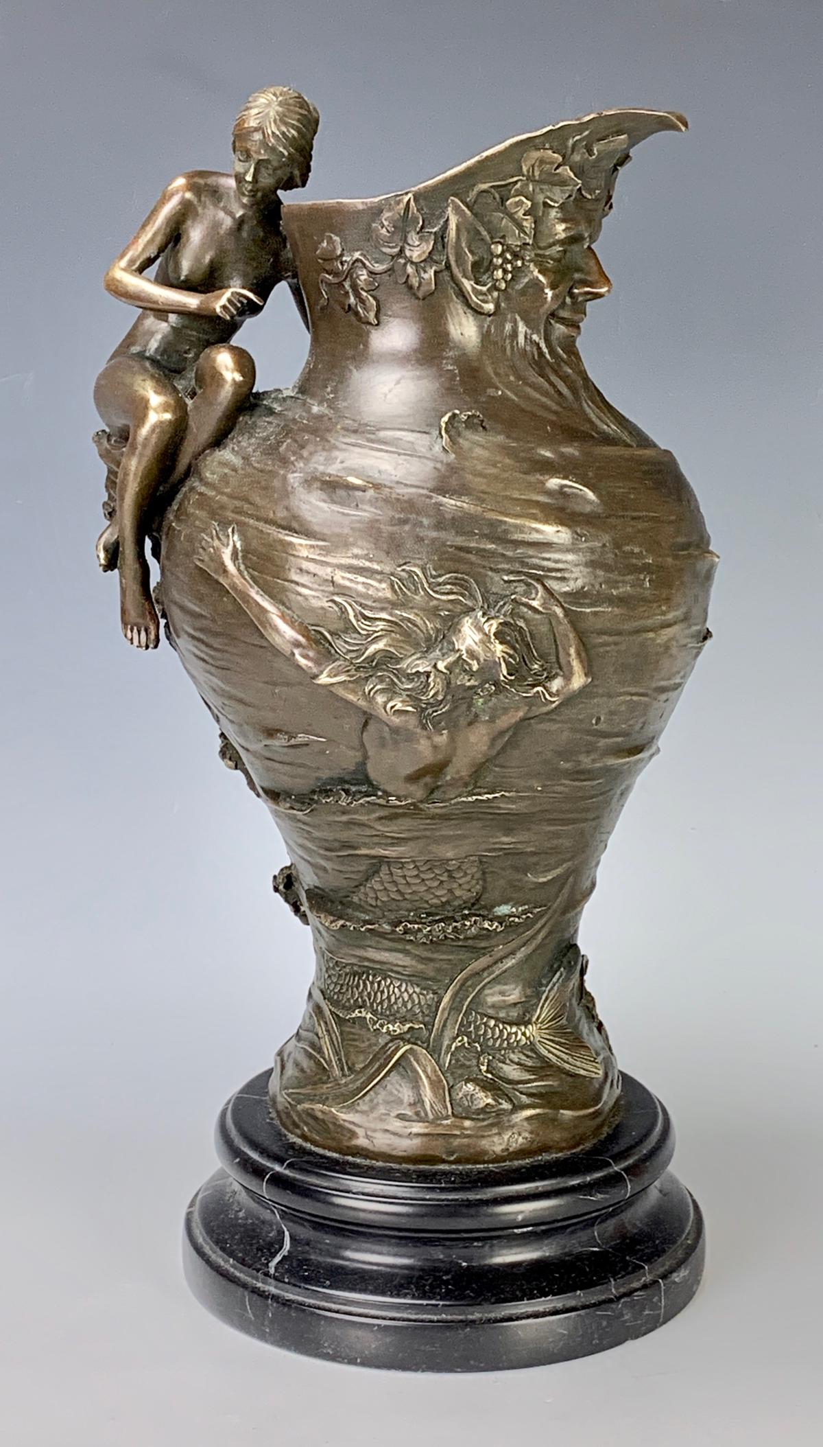 Art Nouveau Style Bronze Figural Pitcher: Signed "Alexandre Clerget", depicting a nude sitting on shoulder of pitcher and nautical designs, mounted on a black marble base, very good condition, 13.75" height
