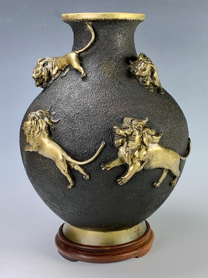 Japanese Bronze Vase with Lions, Meiji: Having a bronze Japanese vase, Meiji period, decorated with raised relief lions throughout, mounted on a wood base, good condition, 13.5" height