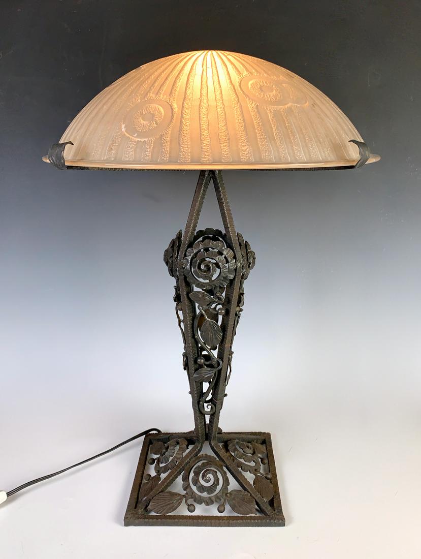 Art Deco Signed Daum Nancy & Iron Table Lamp: A domed art deco acid etched white lamp shade with deco design, signed "Daum Nancy France" with cross of Lorraine, mounted on a wrought iron ornate base, very good condition, 23" height, 16" shade dia