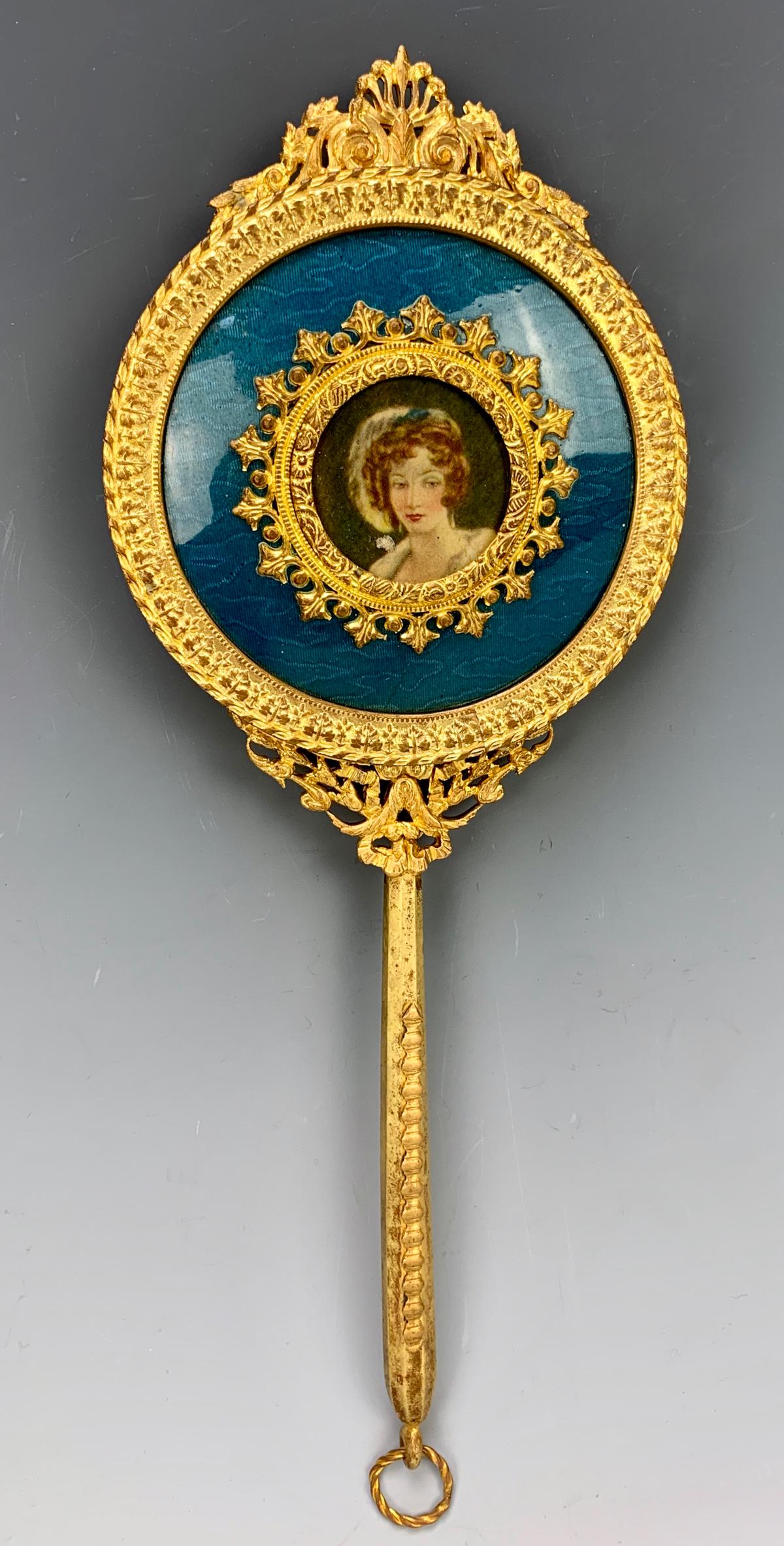 Gilt Bronze & Enamel Hand Mirror with Portrait: Having a gilt bronze hand mirror decorated with blue enamel and a portrait print of a lady, good condition, 10" length