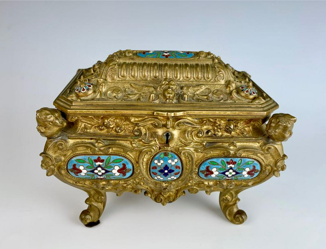 Antique Champleve Enamel & Bronze Jewelry Box: Great bronze box decorated with a child's face protruding from each corner, top lid has winged lady faces on front and back, several panels of champleve enamel design, red velvet interior, good condit