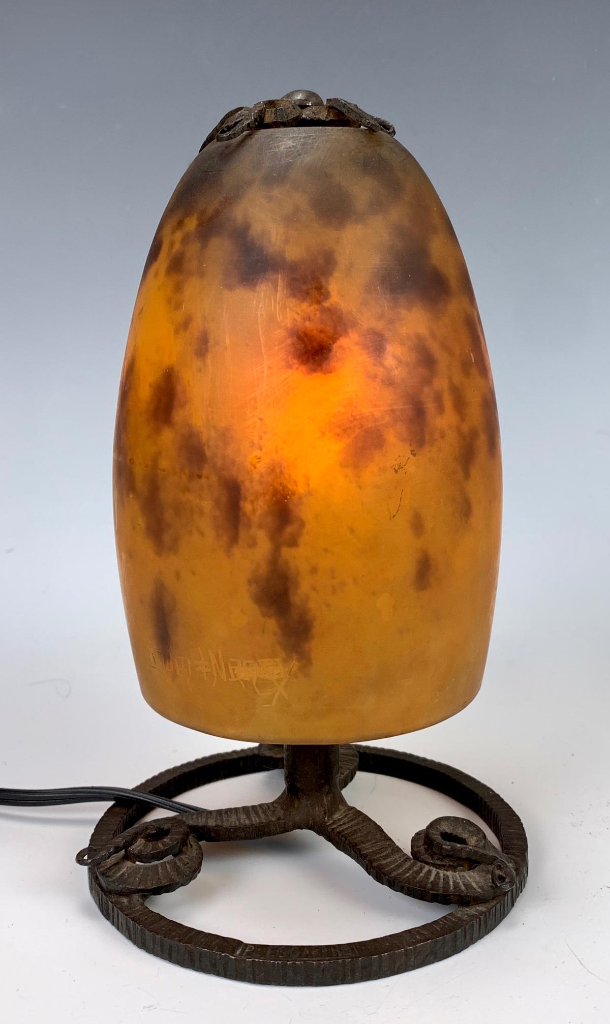 Signed Daum Nancy & Wrought Iron Boudoir Lamp: A mottled orange glass shade signed "Daum Nancy" with cross of Lorraine, mounted atop a swirl designed wrought iron base, good condition, 7.5" height *Electrical warning: wiring should be inspected be