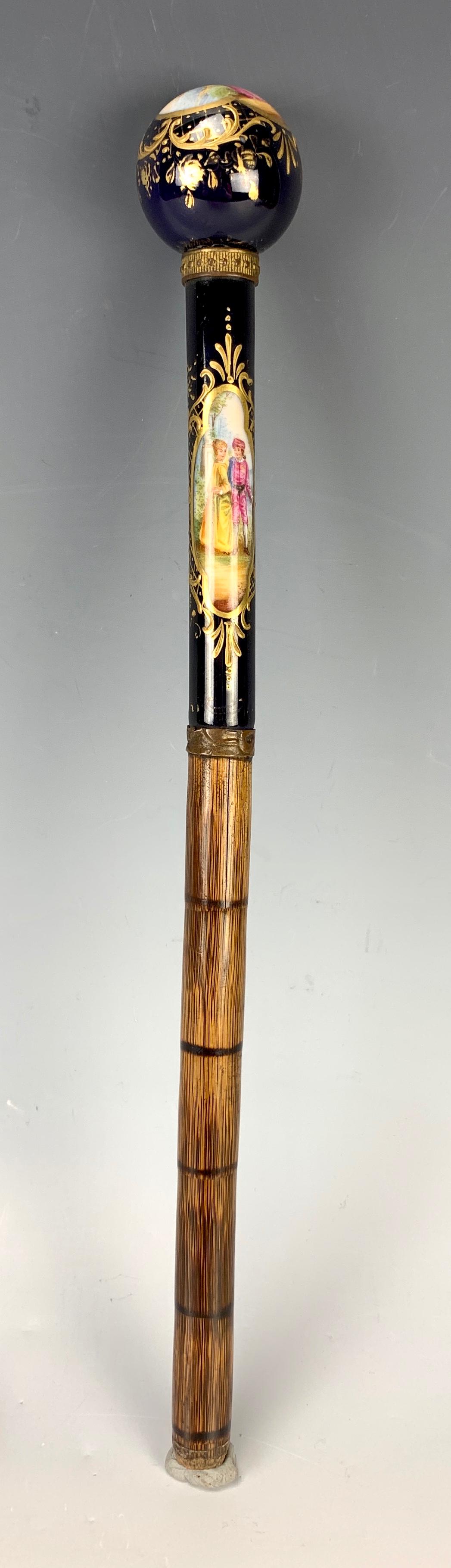 Sevres Hand Painted Porcelain Parasol Handle: Circa 1880, having a French hand painted "Couples" with cobalt blue and gilt trim parasol handle, attached to a bamboo pole, very good condition, 12.25" total length, 5.25" length of actual porcelain 