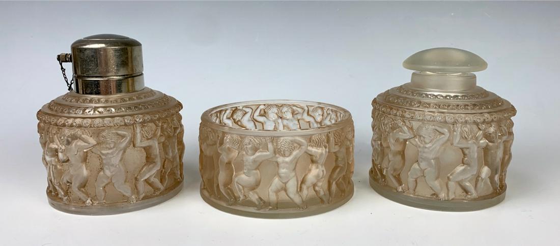 R. Lalique Clear Glass Enfants Toilette Set: Circa 1931, stenciled "R. Lalique France", consists of a powder jar, atomizer and jar without cover, clear frosted glass with sepia patina, atomizer has chip on bottom edge, larger jar is without cove