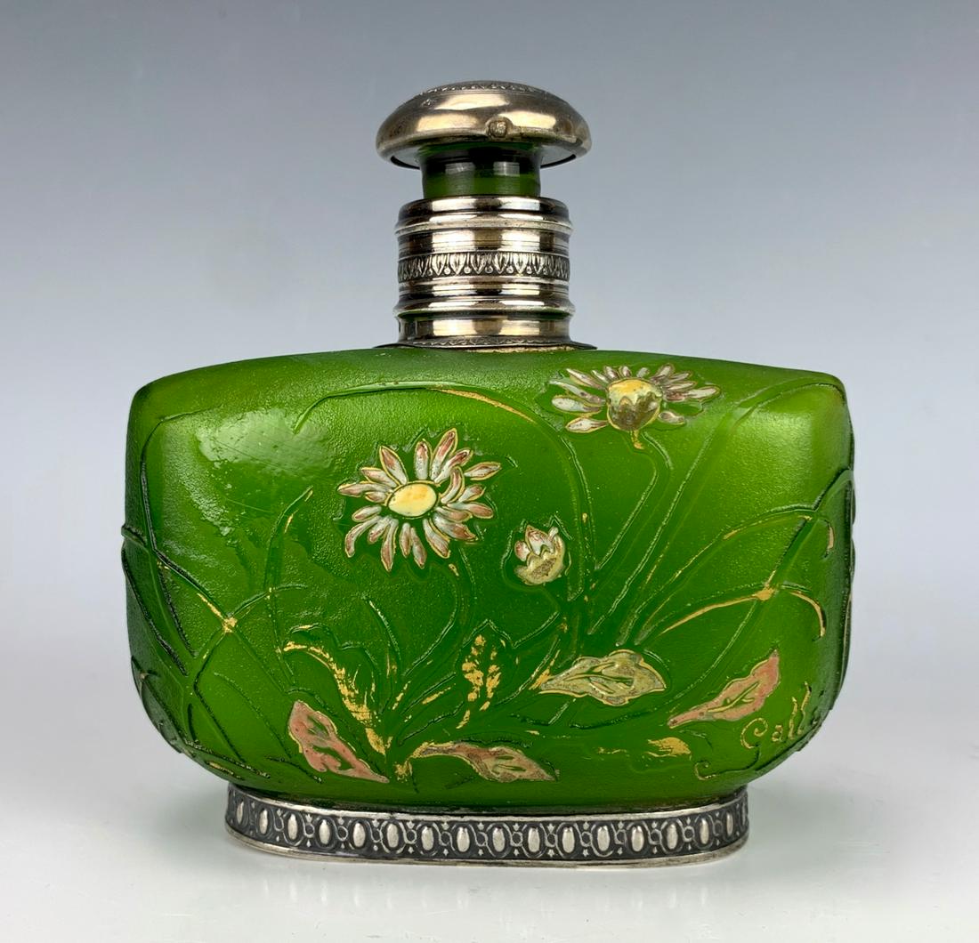 Signed Galle Glass Perfume Bottle with Sterling: Having an oblong spring green glass perfume bottle with daisies and blades of grass in cameo with pin, yellow and white enamel enhanced with gold, signed "Galle Nancy Depose", frame of the collar, hee