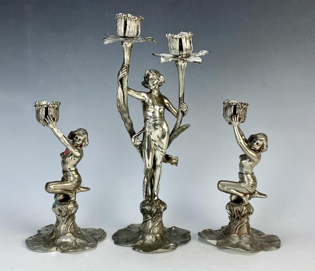 Art Nouveau 3 Piece Candelabra Set C.1900: Marked "Argentor Zinn. Made in Austria", made of pewter, consists of a partially nude lady holding up 2 candle arms and lily pad base, has matching 2 candelsticks, good condition, 13" tallest