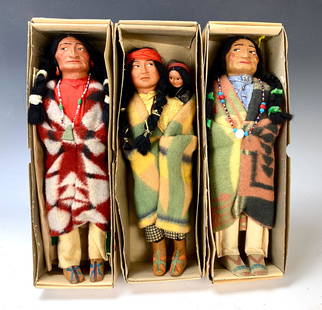 Group of 3 American Indian Skookum Dolls: Group of 3 American Indian Skookum Dolls. Female has papoose baby. All in their original boxes. Elderly man w/ yellow feather is marked under foot and is the tallest at 13 1/2".Very good