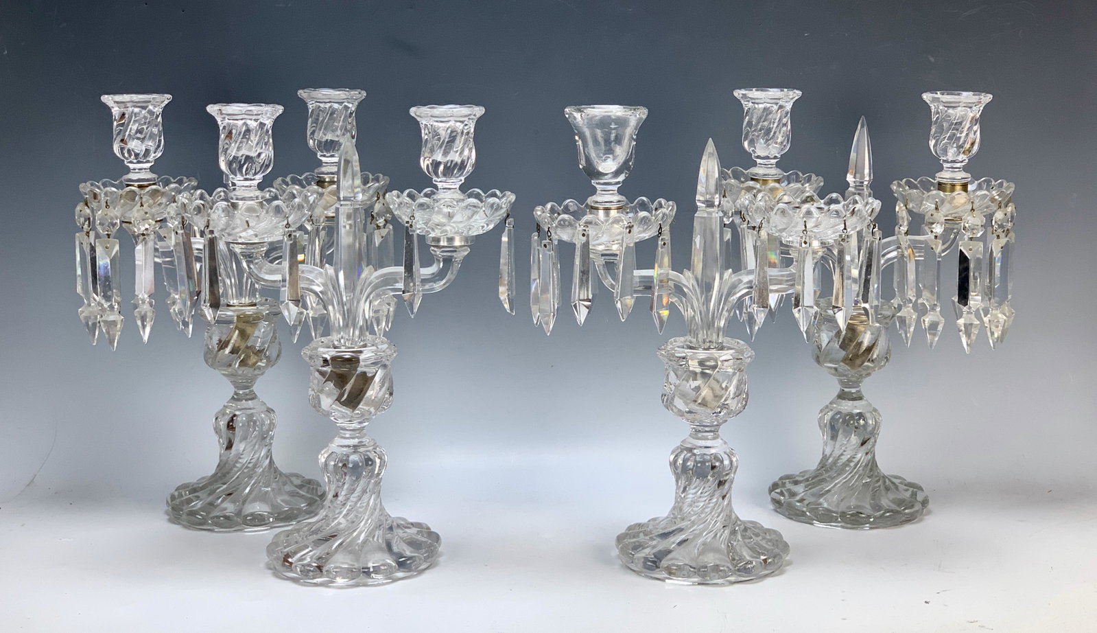 Set of 4 Baccarat Crystal Candelabra: Swirl pattern candelabra, two are signed "Baccarat", 2 unsigned, one missing a cup, one with replaced cup, one pair with shorter prisms, 4 missing prisms in all, 13.5" tall