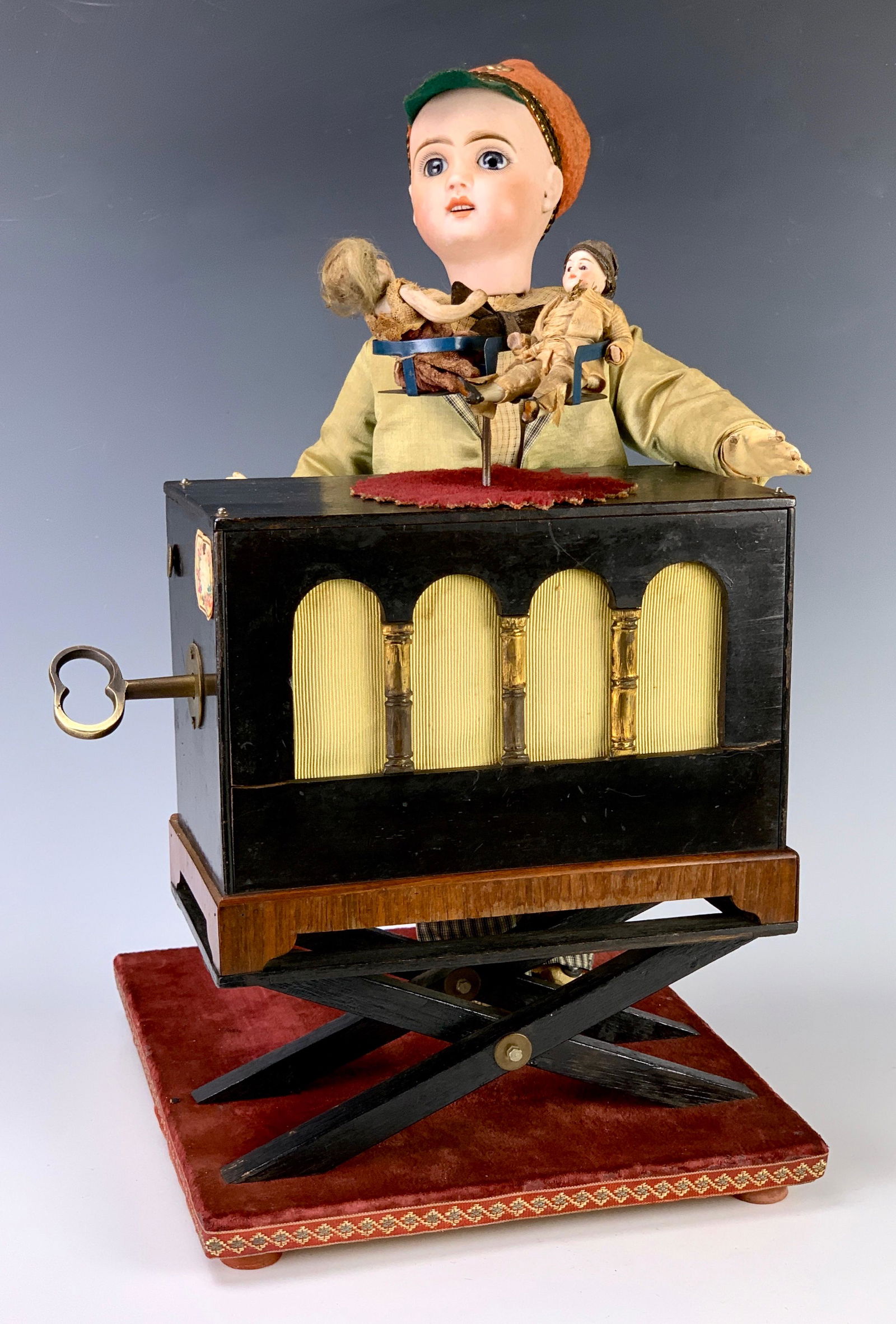Rare Gustave Vichy Musical Organ Grinder Automaton: Circa 1880 France, wonderful automaton of a young boy with hat turning his head from side to side while turning the handle of the barrel organ which plays 2 airs of music, unmarked Jumeau bisque head