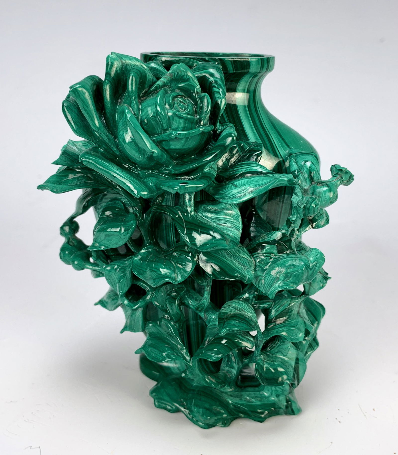 Chinese Carved Malachite Vase with Flower: A malachite carved vase decorated with a carved flower amongst foliage, minor damage in upper right leaves and some leaves with chipping, 4" tall x 3" wide x 2.25" deep