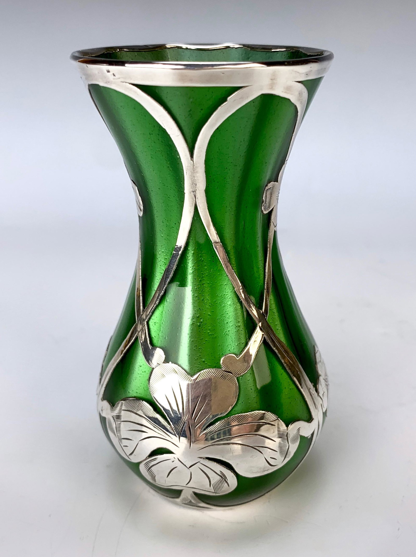 Loetz Metallic Lustre Green Vase: Loetz Metallic Lustre Green Vase, 4 3/4" high with sterling flower nouveau style. Small horizontal half inch hairline inside only, below rim. Marked for La Pierre sterling on bottom edge. Condition: G