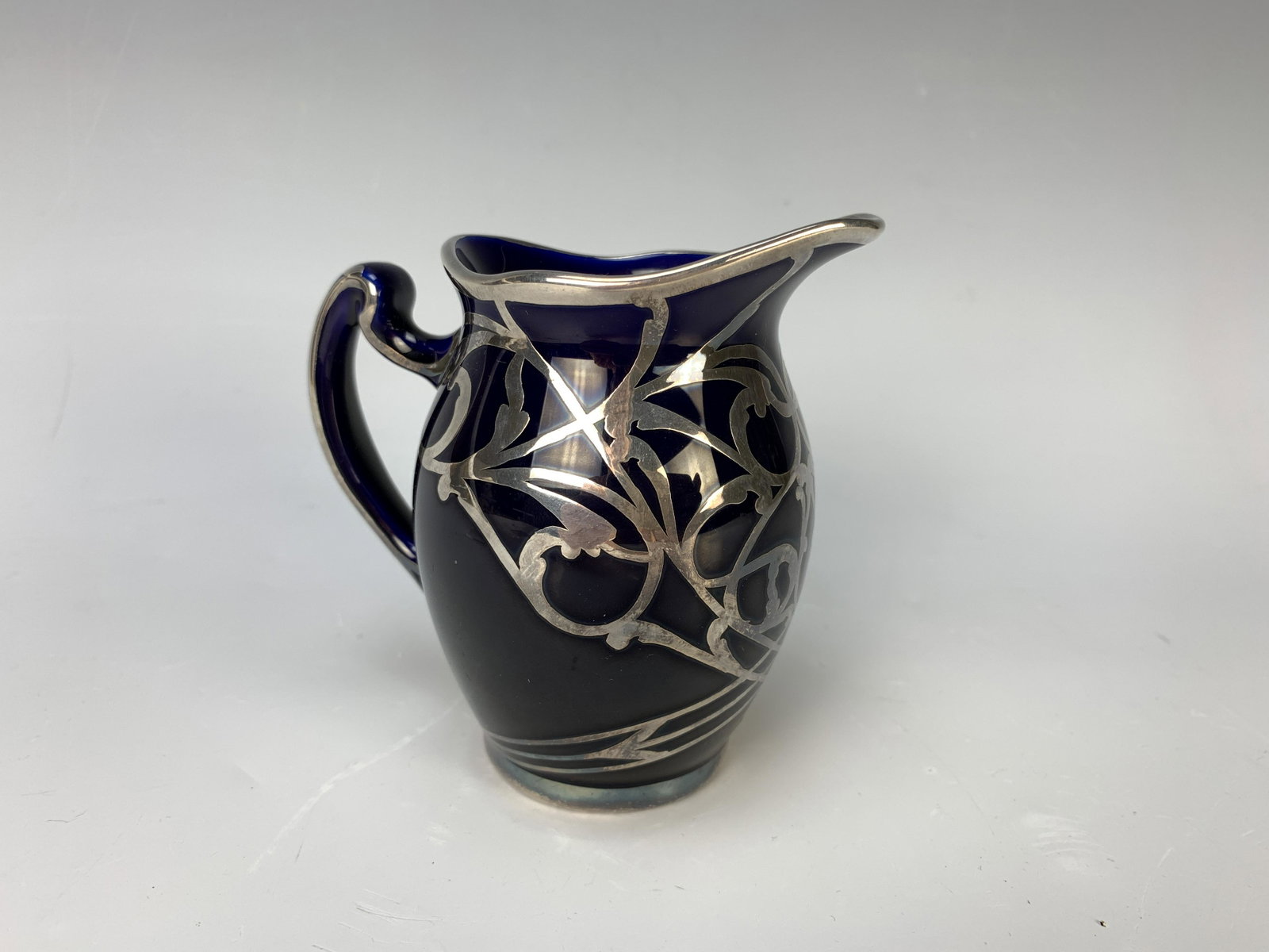 Lenox Cream Pitcher: Has sterling silver overlay design, 4" high x 4" handle to sprout and weighs 152 grams. Partial Lenox stamp on bottom, silver unmarked, very good condition.
