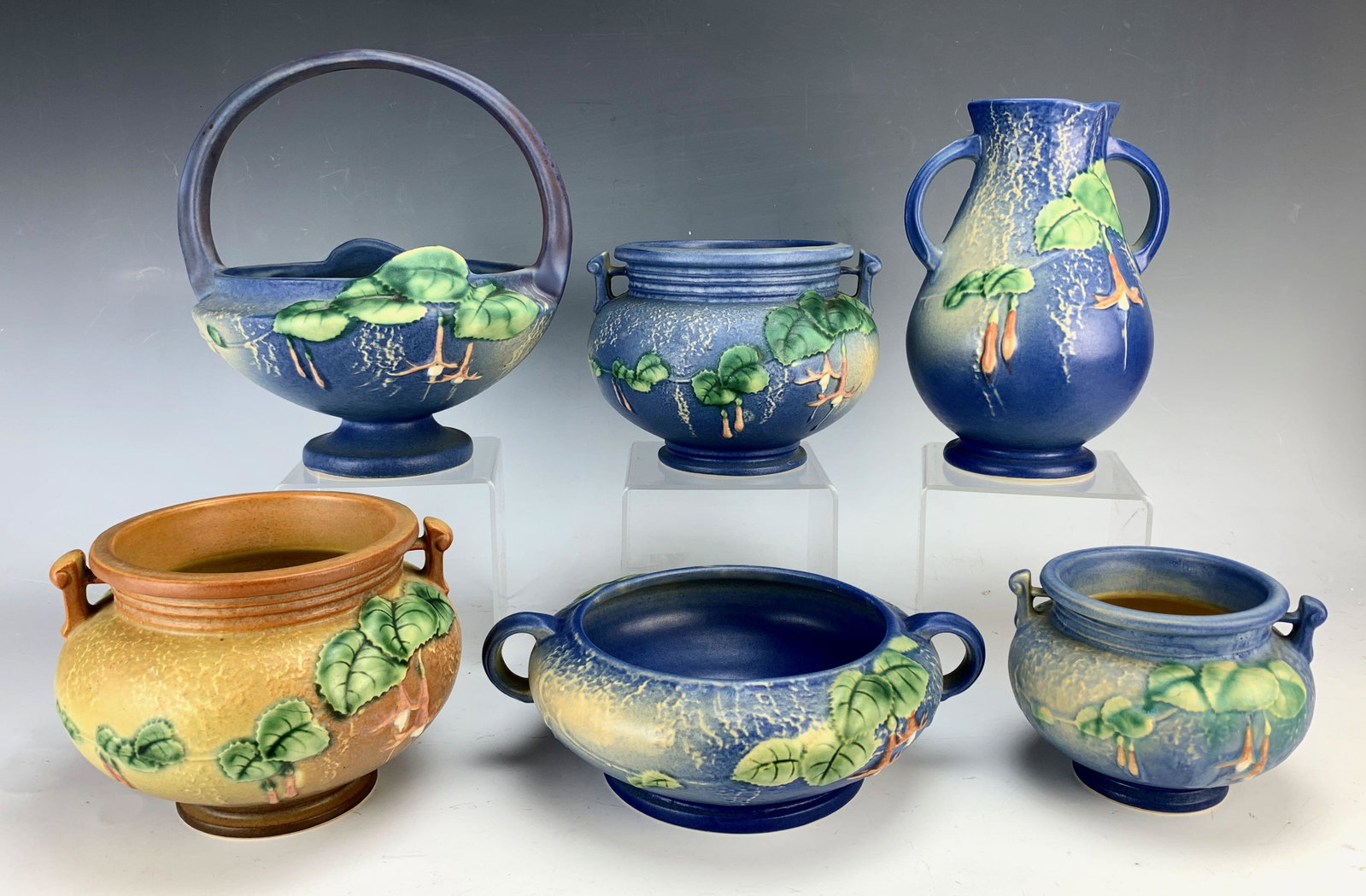 Group of 6 Roseville "Fuschia" Pottery C.1939: Includes 1 basket with built in flower frog, 4 bowls and 1 vase. 8" tallest. Condition: good. Addendum: Top center blue bowl has a 1/2" x 1 1/16" chip.