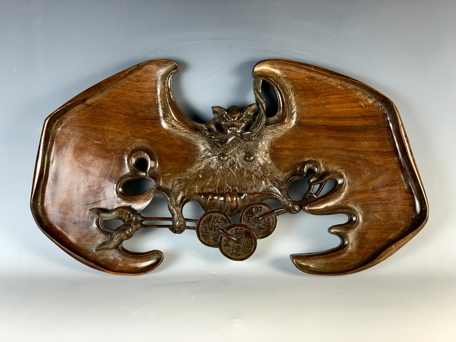 Large Chinese Wood Carved Winged Bat: Beautifully carved wooden figure of a bat with outspread wings and Chinese coins at the bat's feet, we don't know the symbolism, has good age, very good condition, no damage, 21" wide and 12" tall