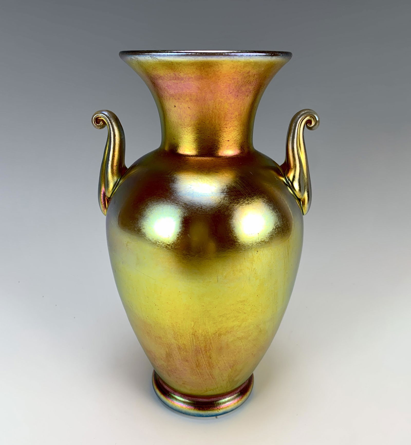Steuben Gold Aurene Handled Vase Sgd: A beautiful iridescent gold Steuben Aurene art glass vase with two applied handles, signed "Steuben Aurene", 8" tall, good condition.Have a similar item to sell? Email us at info@treasureseekerauction