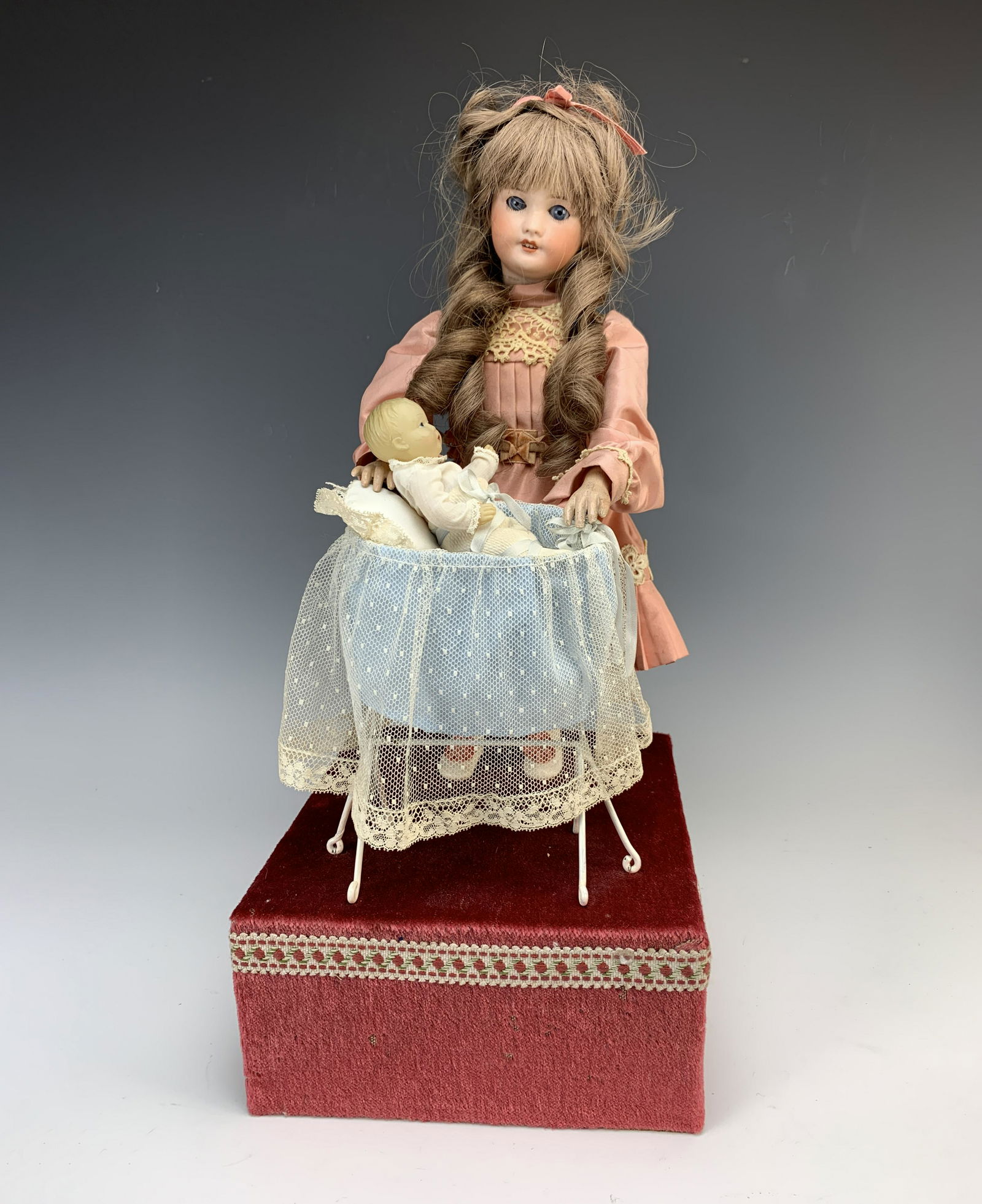 SFBJ Bisque Head Doll Automaton "Rocking Baby": Wonderful signed S.F.B.J. bisque head doll wearing pink and white lace dress, marked "S.F.B.J. France #301 Paris". With electric mechanism, when plugged in she rocks the cradle to and fro, the baby is