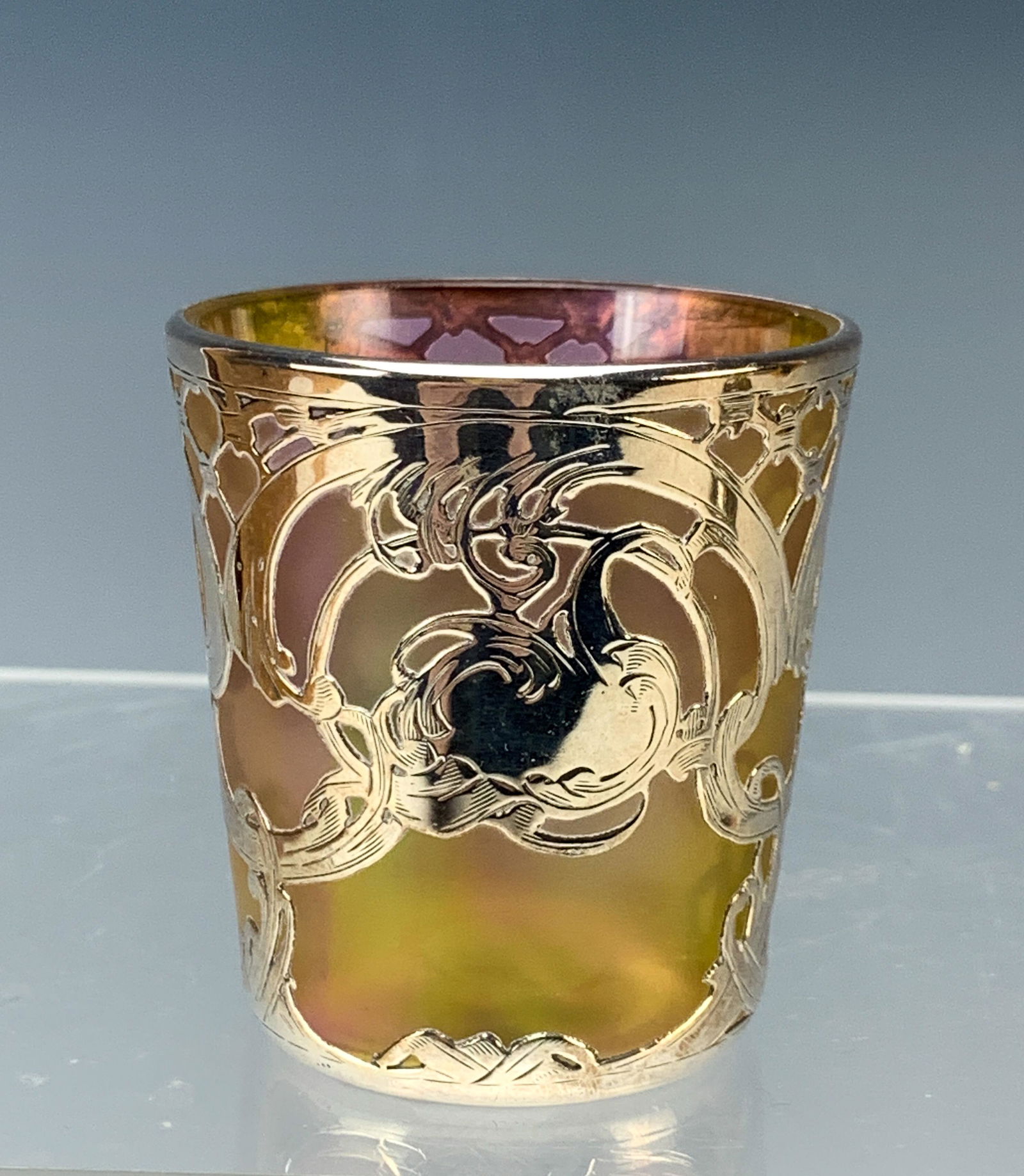 Iridescent Sterling Silver Overlay Cup: This cup measures 2 3/8" high x 2 1/8" in diameter and weighs 87 grams. No monogram in the cartouche on the front. The sterling is signed with the 'L' logo for La Pierre. Condition is excellent.