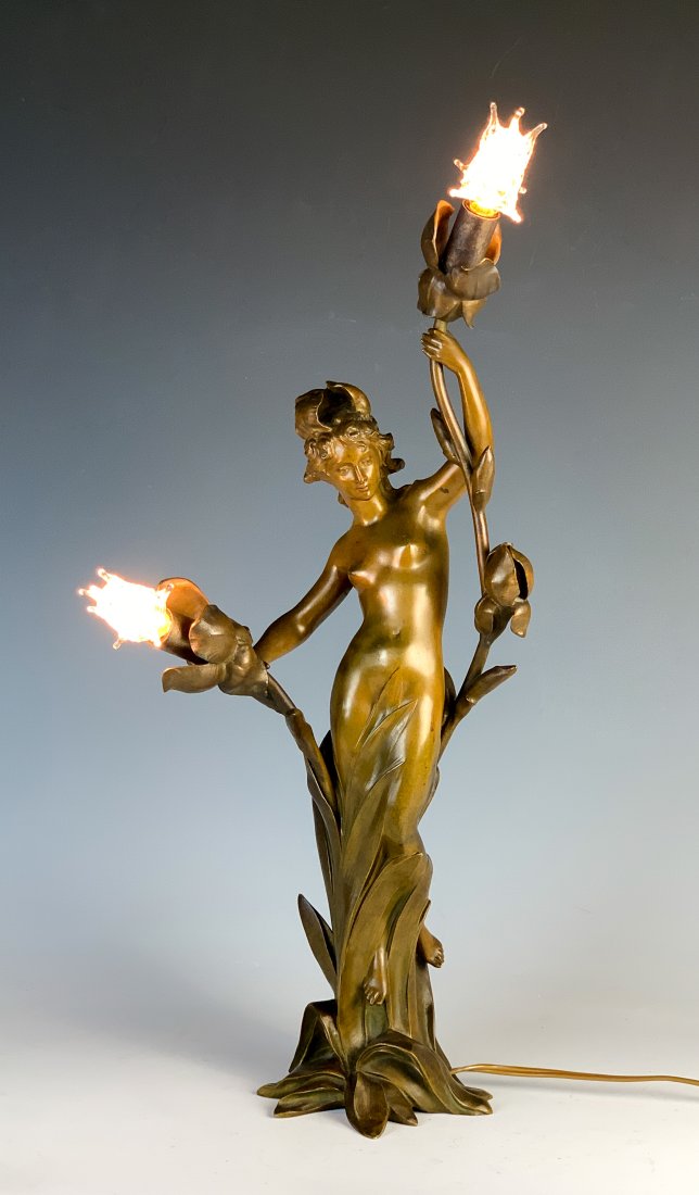 Jean-Baptiste Germain (1841-1910) Bronze Nude Lamp: Circa 1900. A beautiful bronze Art Nouveau nude lady lamp. Depicting a nude lady in a brown patina amongst flowers and vegetation. Lights protude from the flowers. Signed by the sculptor. Size: 20" ta