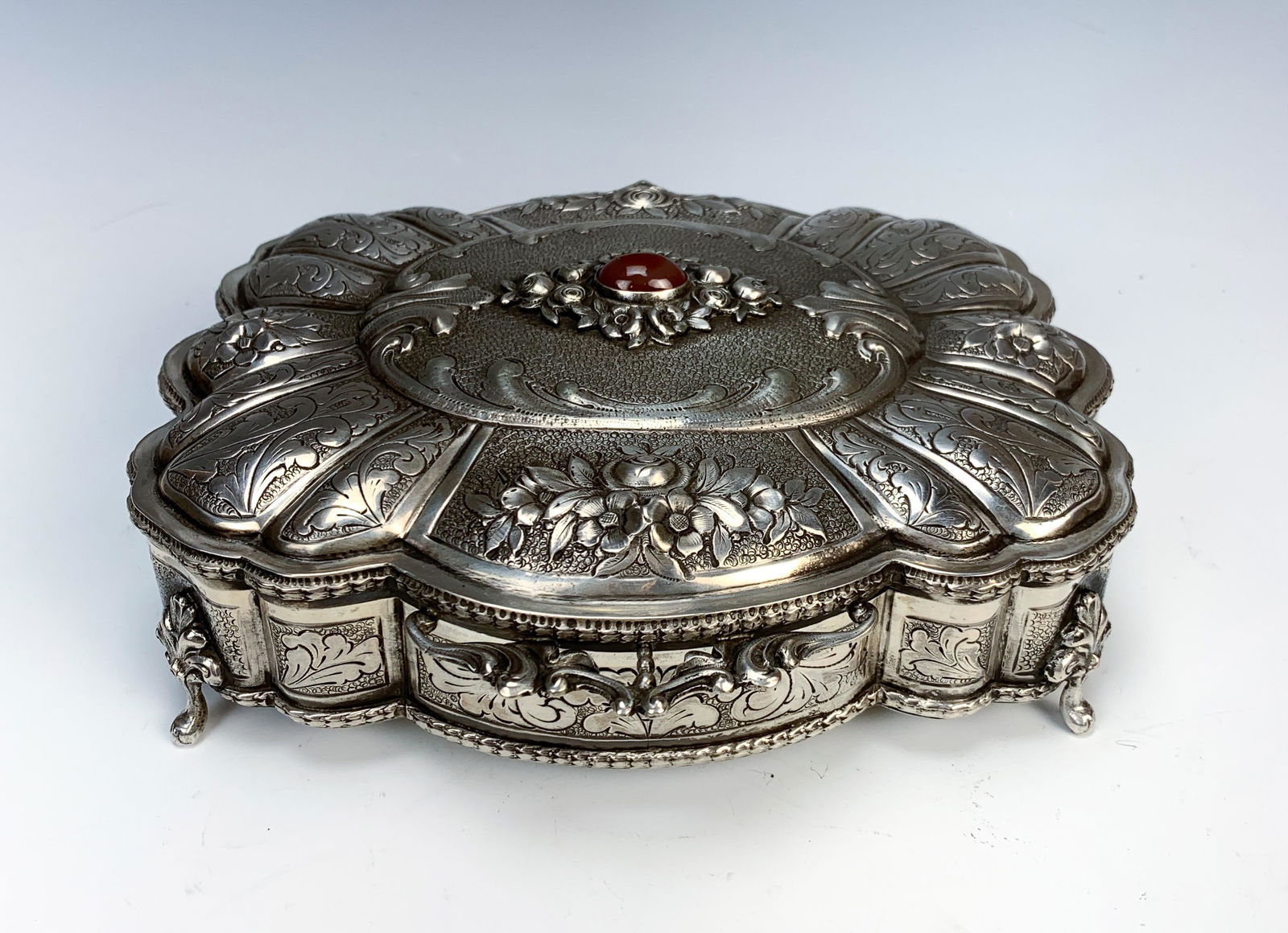 Buccellati 800 Silver Fancy Box.: Beautiful sculptured 800 silver (Italian) box with a 20x13mm oval cabochon cornelian. The top sides chased with flowers and decorative design. Sides also chased with decorative design. Hinged lid. Mar