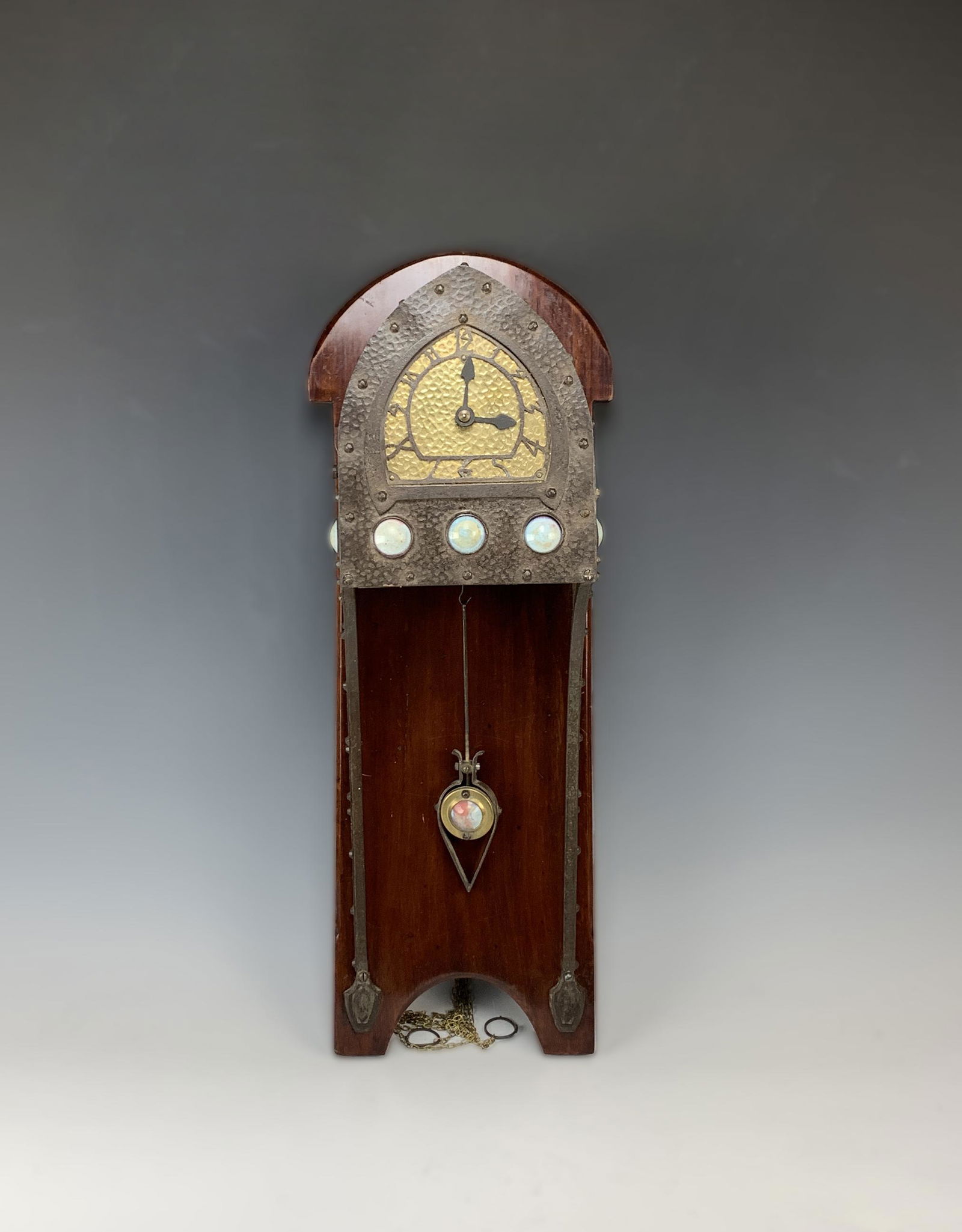 Albin Muller Rare Art Nouveau Wall Clock w Jewels: Albin Muller (German 1871-1943), circa 1900, hand hammered metal wall clock with 9 circular glass jewels decorating the front and sides, the arched brass dial with graduating numerals, penduum also wi