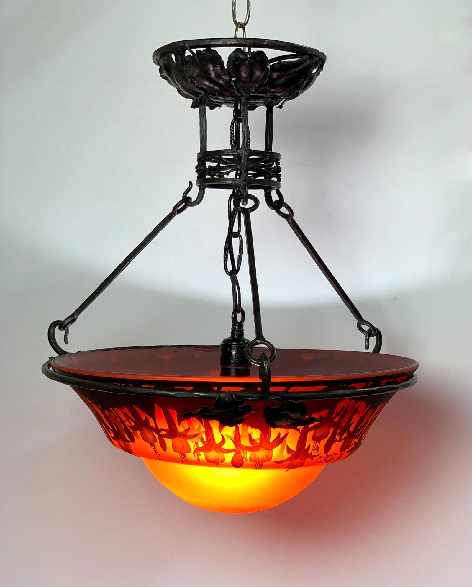 Muller Freres Luneville Cameo Glass Chandelier: C.1920's. A beautiful Art Deco chandelier with frame being wrought iron. The shade is cameo glass in colors of reds/oranges and decorated in dark red with a row of bellflowers. Signed in cameo "Muller