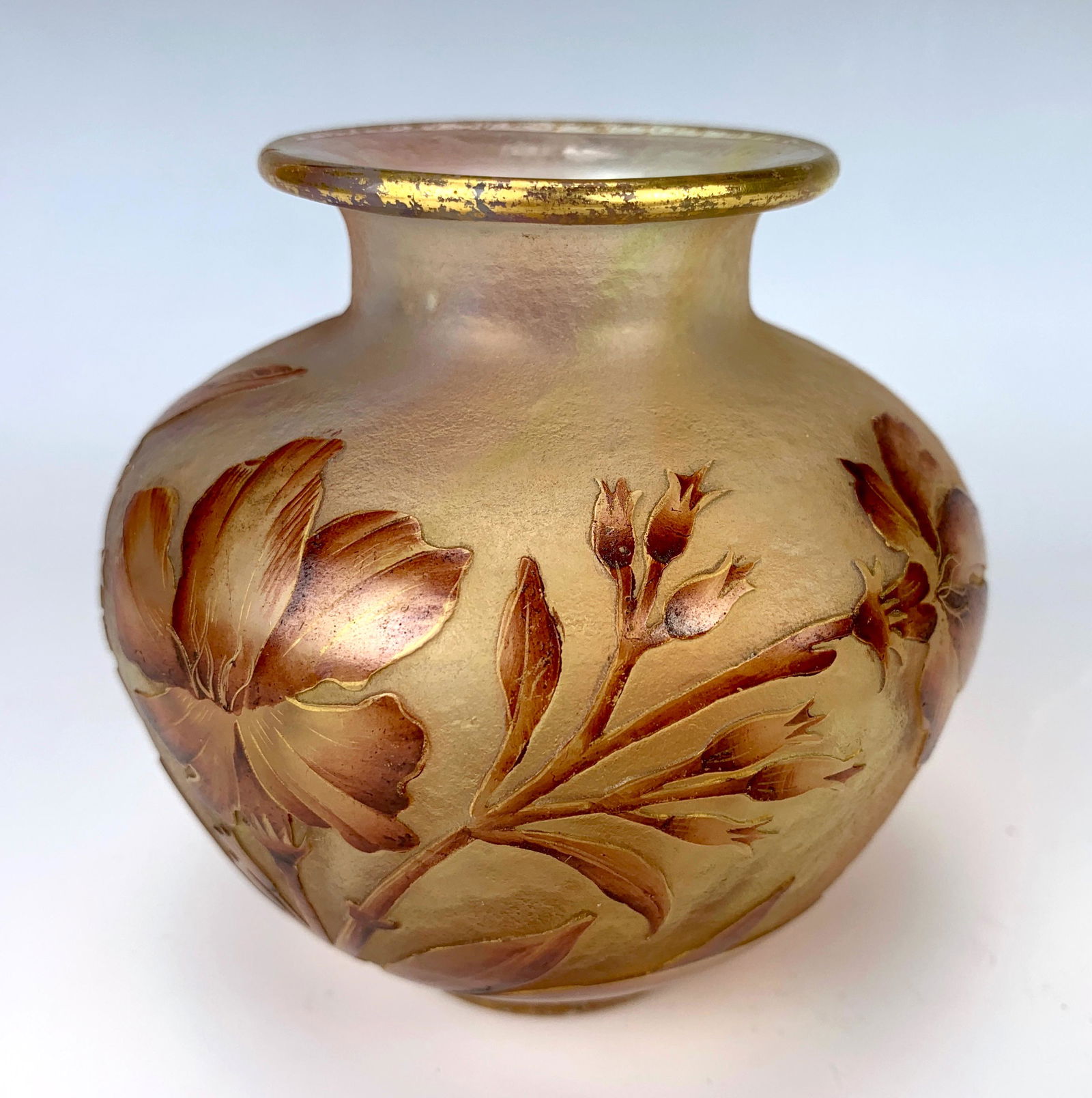 Daum Nancy Cameo Glass Vase C. 1920: Nice signed Daum Nancy squat cameo vase with a pale pink body and having cameo red flowers and leaves decorating the body and a gold rim, signed on bottom "Daum Nancy" with cross of Lorraine, very goo