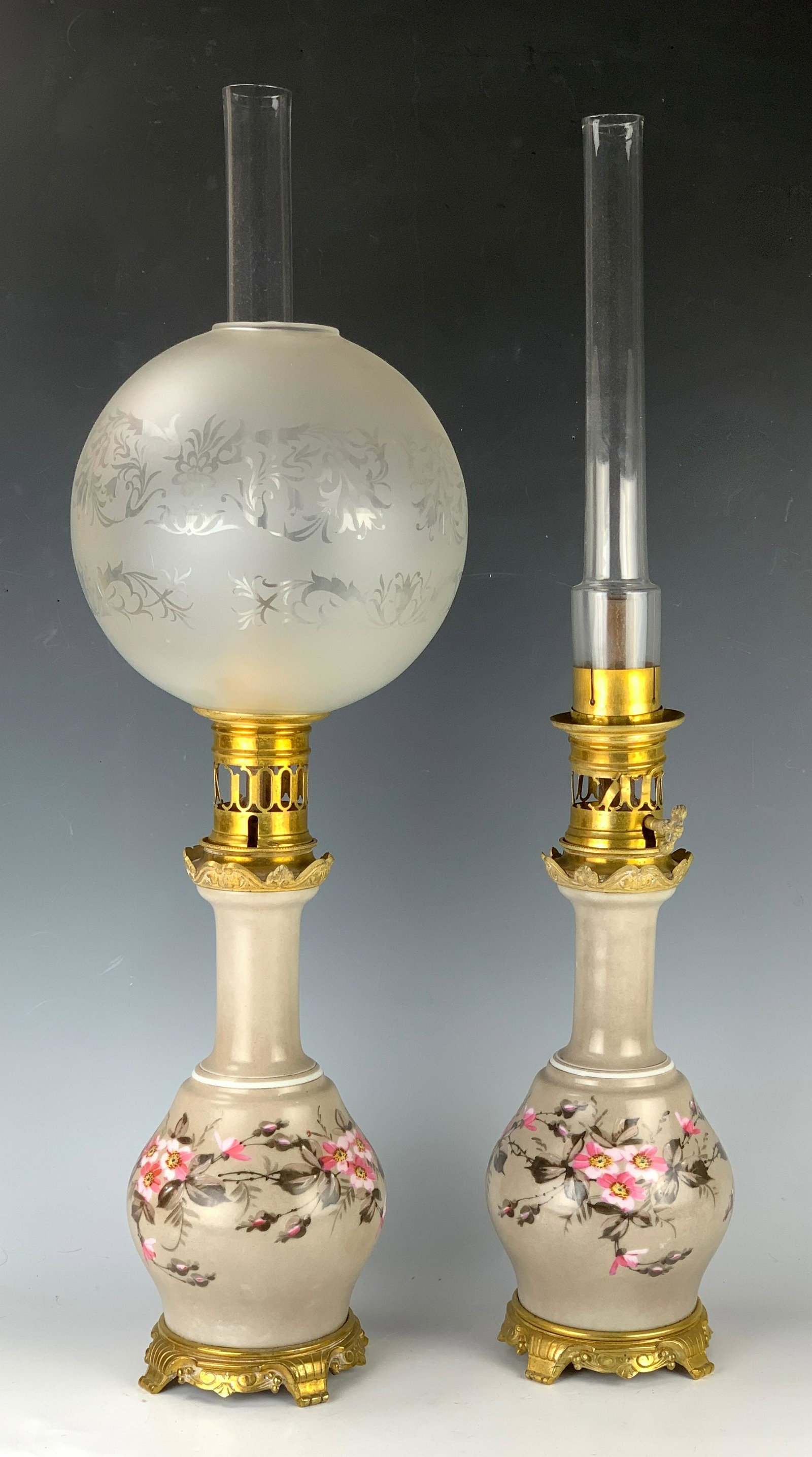 Pair Victorian Oil Lamps, Bronze & Gilt Porcelain: Circa 1900, pair of Victorian gilt bronze and gilt painted porcelain oil lamps, one ball shade missing, good condition, 26" height with chimneys.