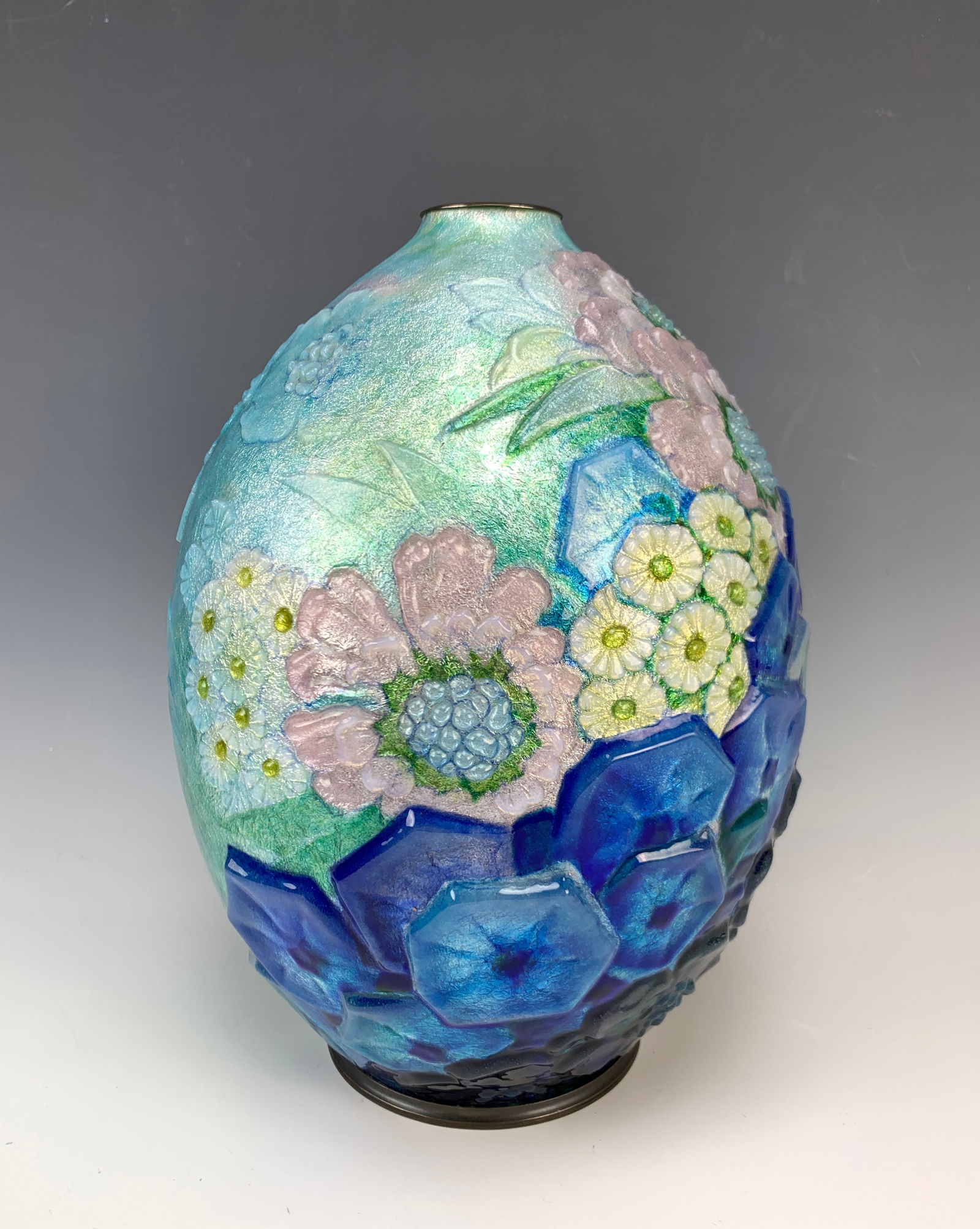 Camille Faure (1874-1956) Large Floral Enamel Vase: Beautiful large enamel over copper floral vase. Decorated fully with raised relief of flowers in colors of blue, green, yellow, and pink. It is signed "C. Faure Limoges." Size: 11 5/8" tall. Condition