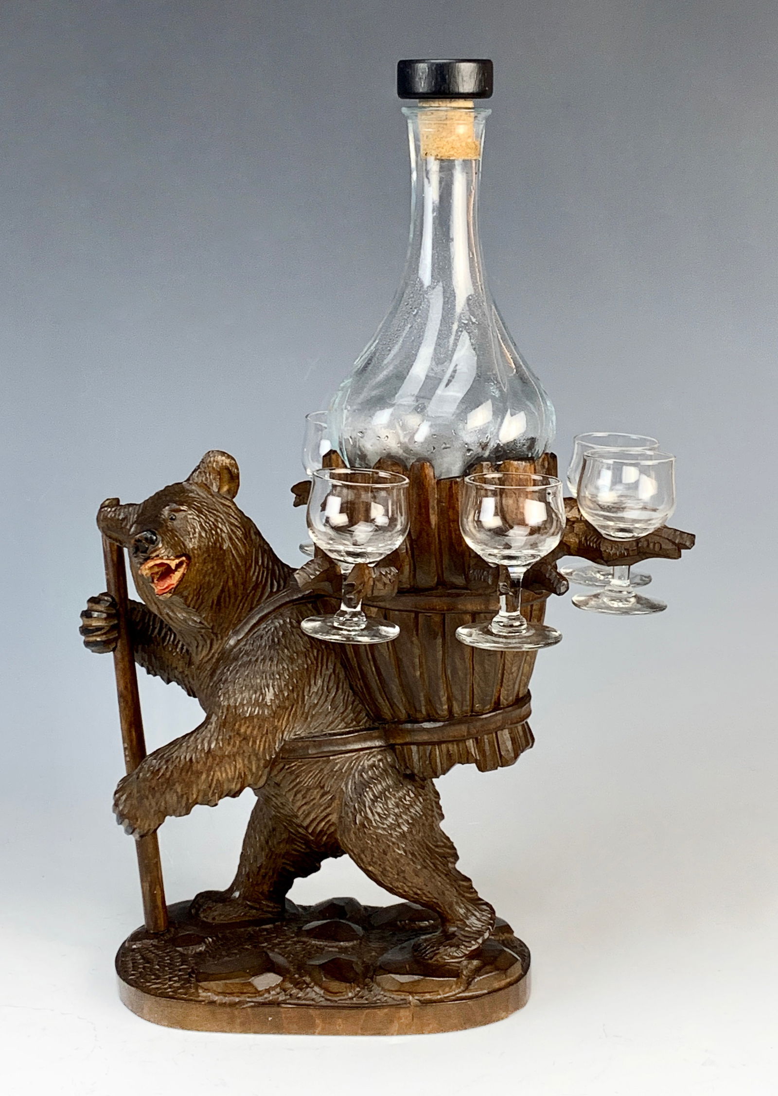 Black Forest Carved Bear Liquor Set: A carved wood bear standing with a bundle of wood on its back, which contains a bottle and glasses. The set is complete. Size: 15.5" tall. Condition: great, no problems.