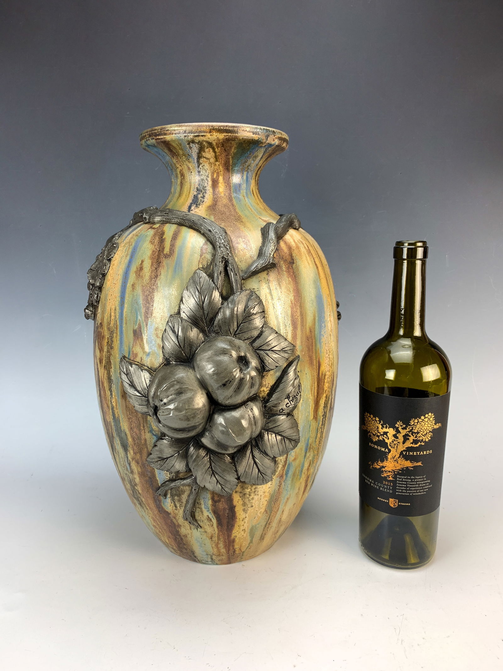 Roger Guerin (1896-1954) Pottery Vase w/Pewter: Circa 1900. Large pottery vase signed on bottom, overlay signed "Guerin". Having colors of grey, brown and blue. Overlaid with a large pewter branch of flowers and fruits. Signed A. Chezal (for Albert
