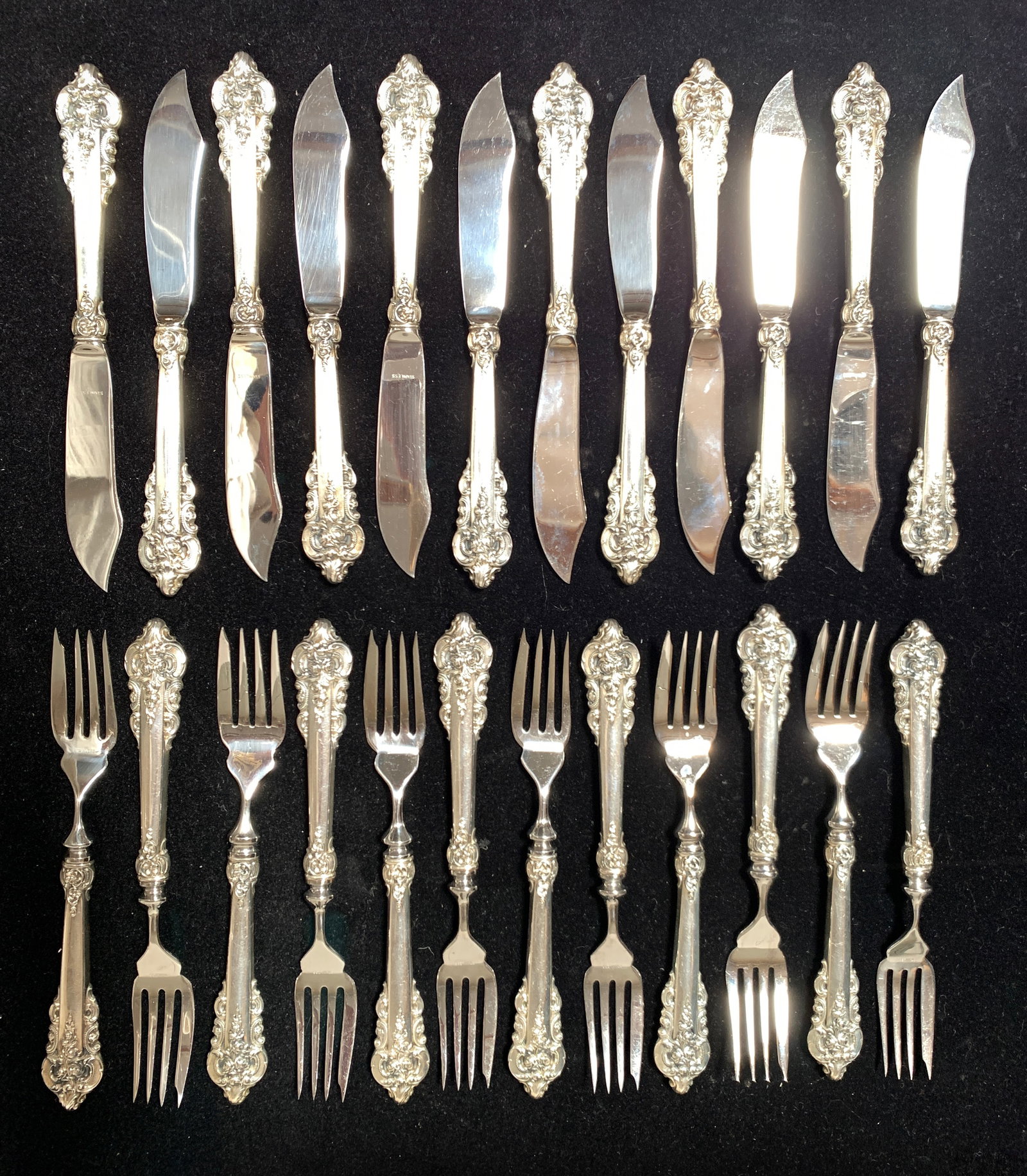 Wallace "Grand Baroque" Sterling Fish Set: 24 pieces, including 12 forks and 12 knives. All have sterling handles and stainless steel prongs and blades. Each piece is marked. Size: 8.5" knives and 8.25" forks. Condition: Good.
