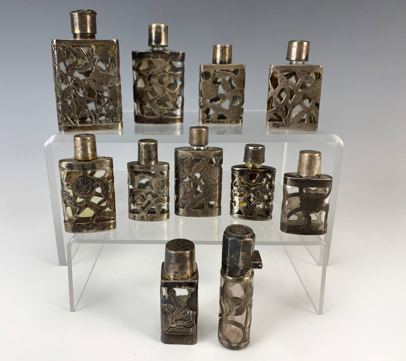 11 Sterling Silver Overlay Perfume Bottles: Collection of 11 sterling silver overlay perfume bottles, marked Made in Mexico. Size: Tallest is 3.25". Condition: Good.