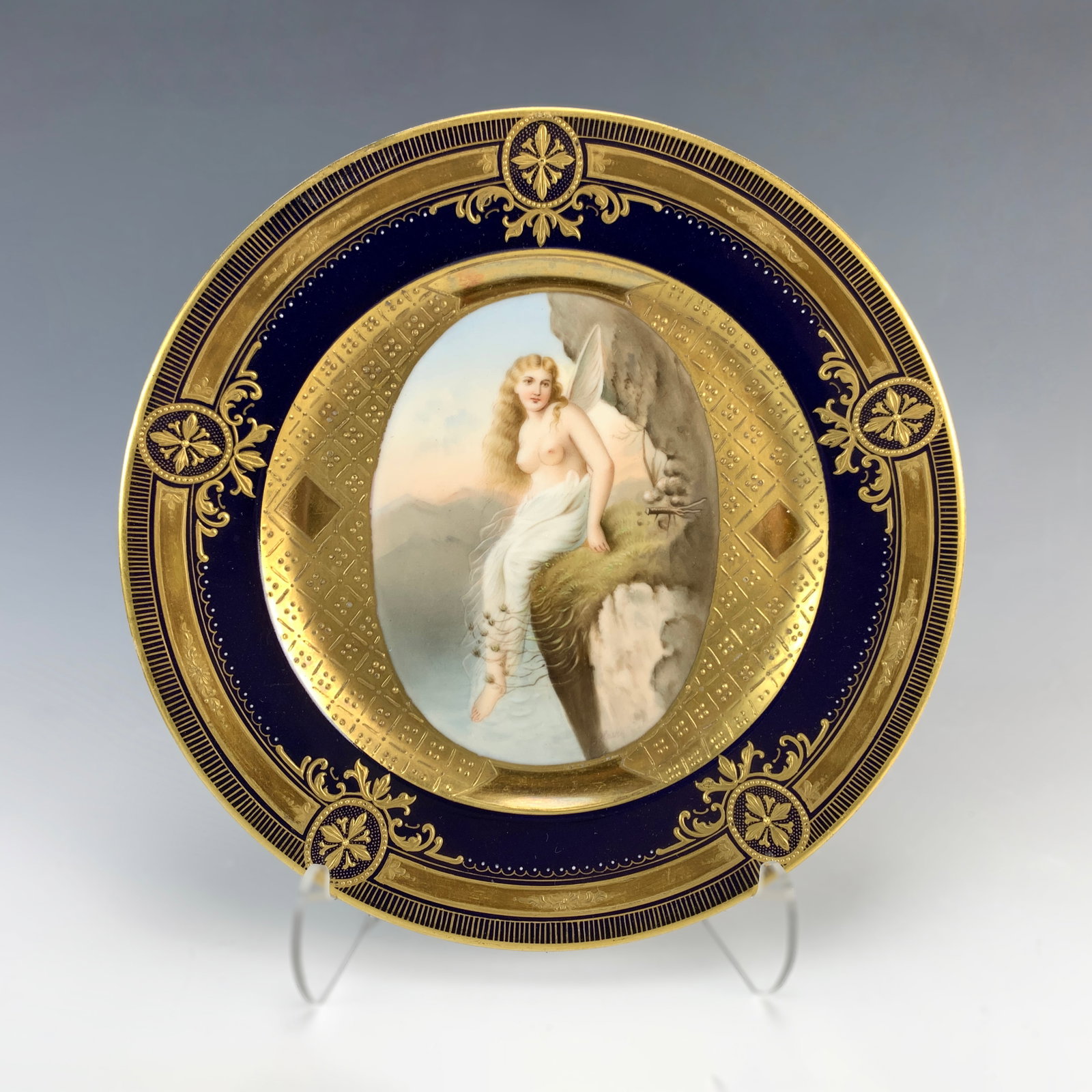 Royal Vienna Painted Porcelain Plate Nude w/Wings: Circa 1900. A beautiful hand-painted porcelain plate with a blond hair topless angel. Signed Doleur. Marked with the blue beehive mark. Size: 9.5" diameter. Condition: very good.