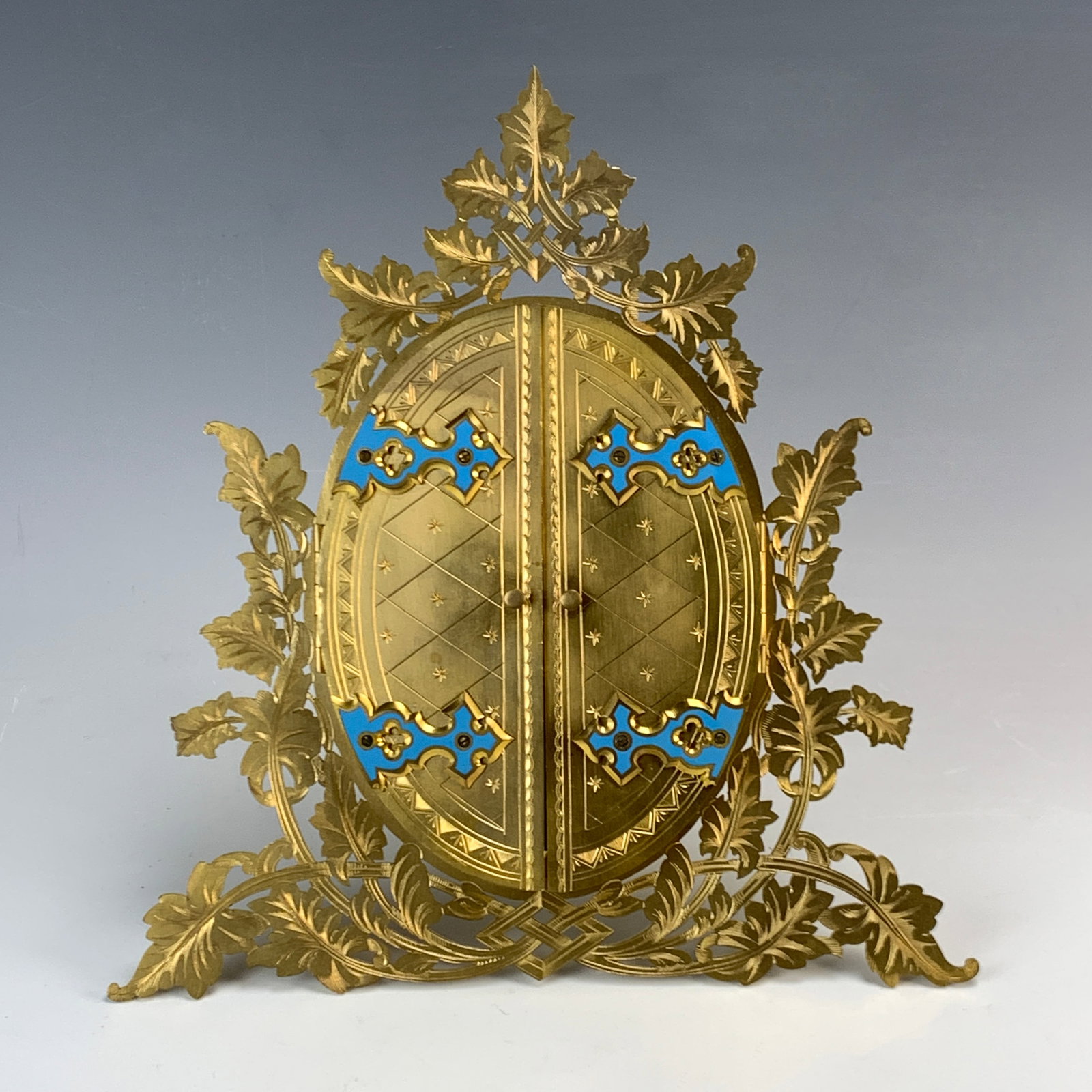Antique Victorian Brass & Enamel Double Door Frame: Circa 1880. This beautiful English Victorian oval double-door brass frame is adorned with blue enamel brackets. It's of high quality, featuring an easel support and marked "H. Rodrigues, 42 Piccadilly