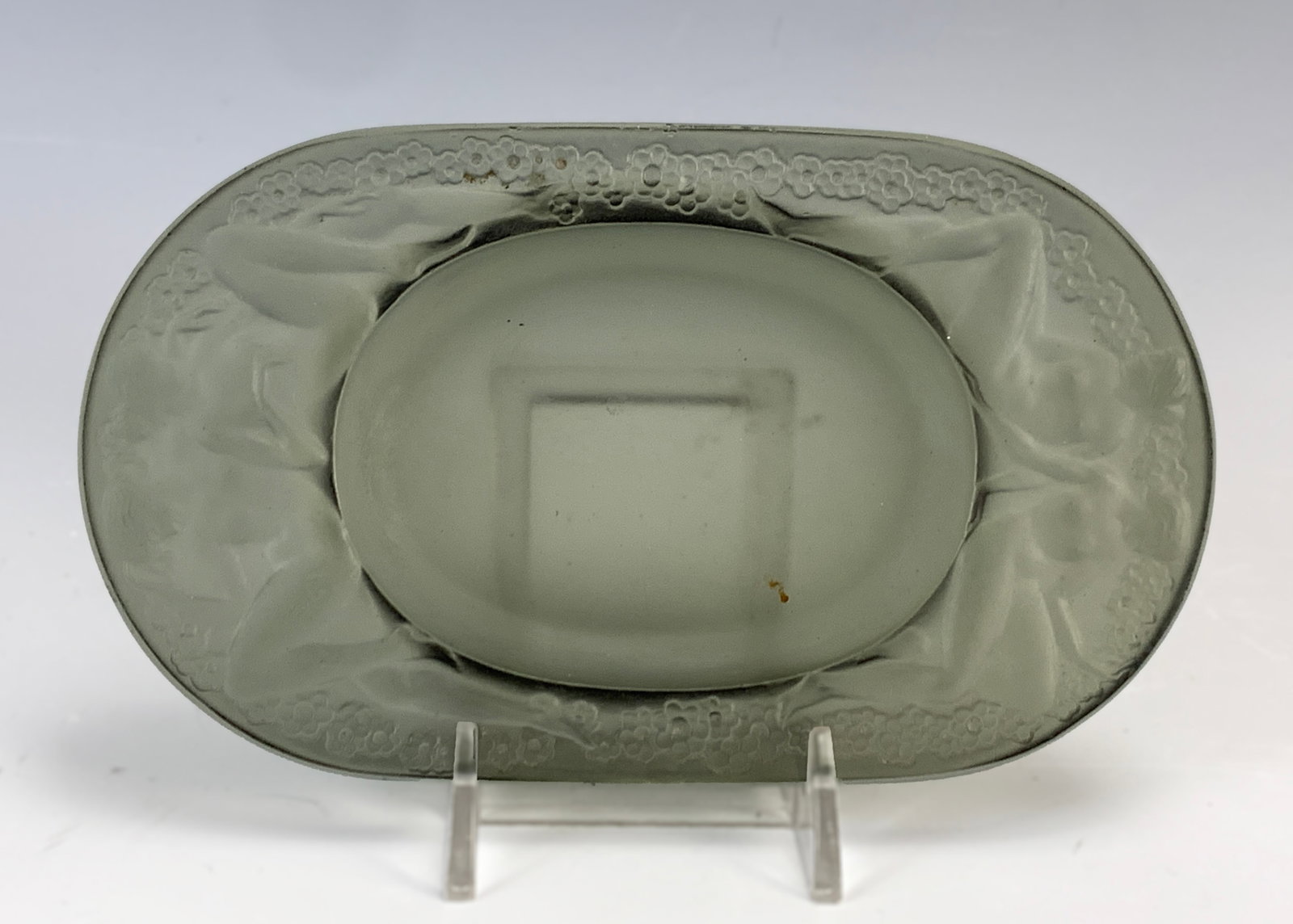 Rene Lalique "Medicis" Smoke Glass Ashtray: Rene Lalique (1860-1945). Circa 1924. Smoke glass ashtray decorated with a pair of nude females sitting back to back at either end on the ledge above the well. Signed on the bottom with raised letteri