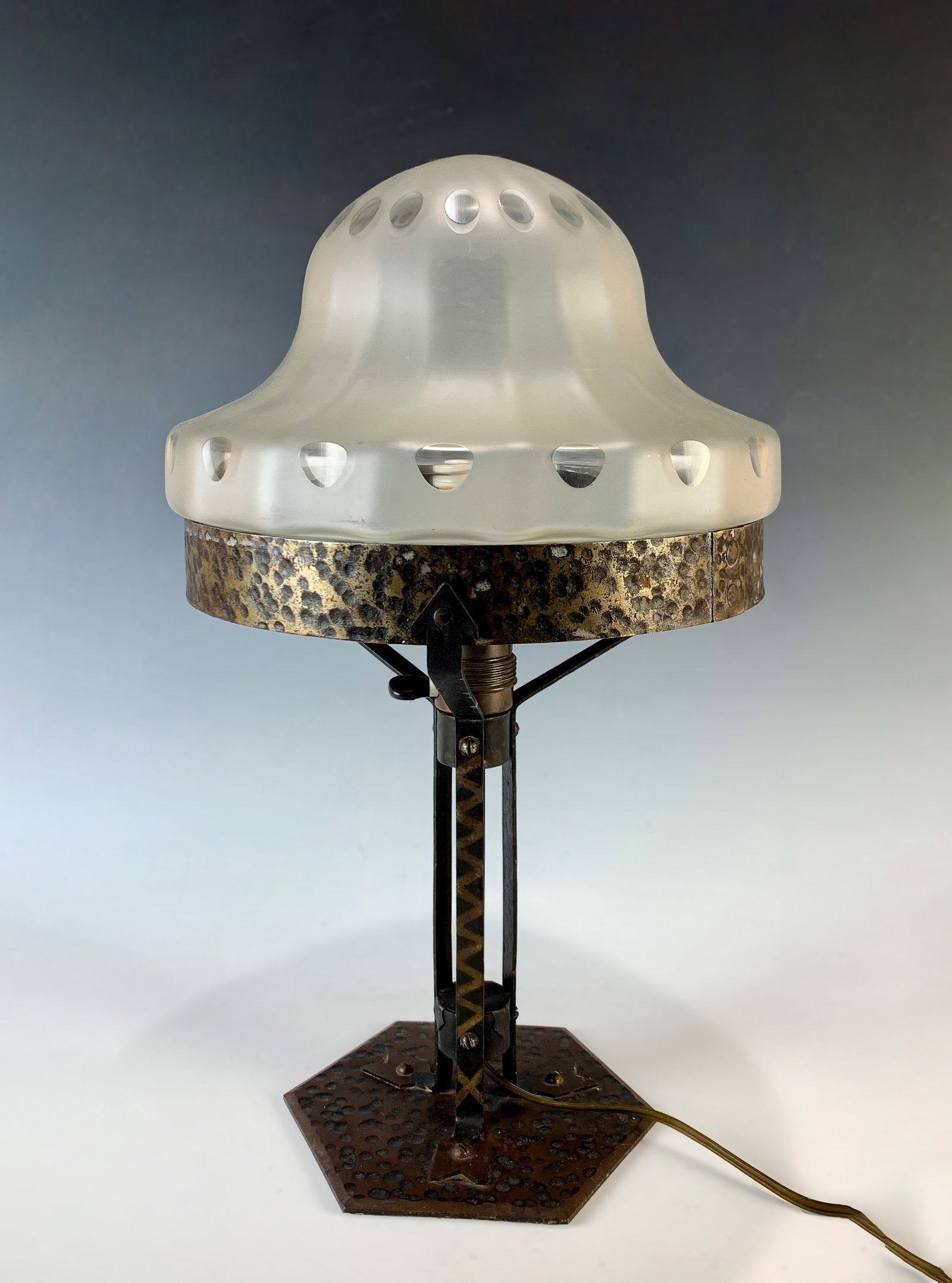 Arts & Crafts Iron & Frosted Glass Table Lamp: Circa 1925, arts and crafts lamp with white frosted glass domed shade decorated with rows of clear glass circular motifs mounted on a hand hammered iron base, 17" x 9.5" very good condition