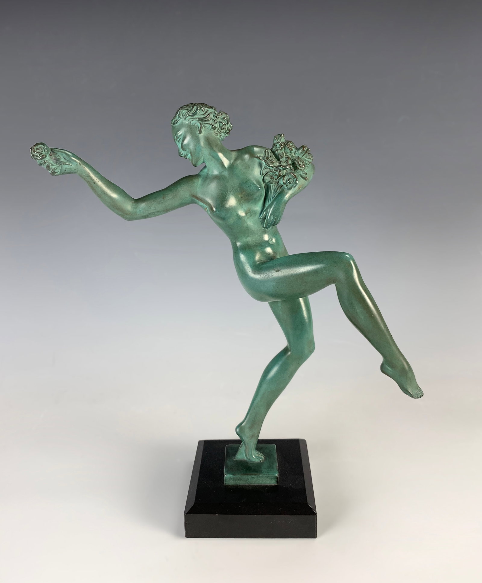 Art Deco Metal "Dancing Flower Girl" signed Fairal: Fine quality Art Deco metal figurine of a girl holding a bouquet of flowers while offering a single flower. Signed Fairal. Green patinated, mounted on a black marble base. Size: 11.5" tall. Condition: