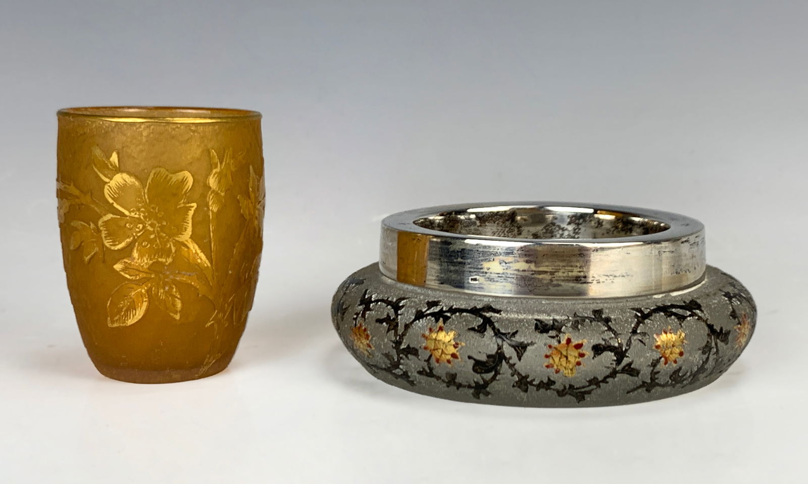 Daum Nancy Small Glass Cup & Open Powder Jar: This lot contains two items, both signed Daum Nancy. A small drink glass in a light orange acid cut body with cameo glass flower and gold highlights, signed "Daum Nancy" with Cross of Lorraine. The se