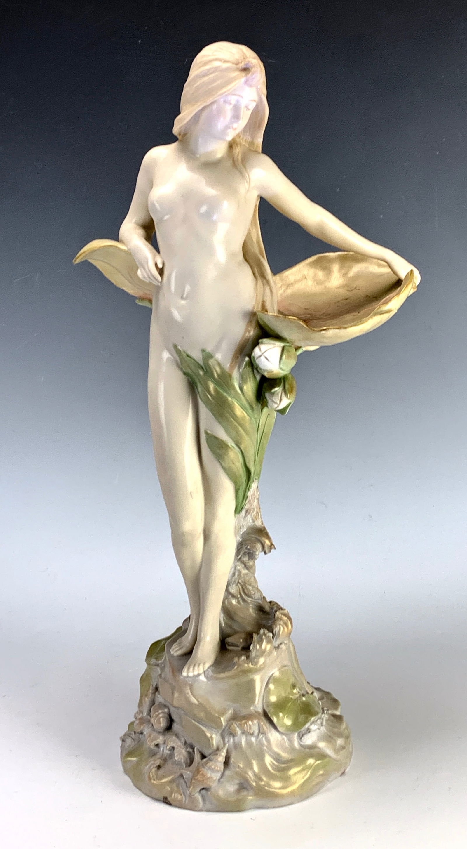 Ernst Wahliss Amphora Porcelain Waterlily Nude: Circa 1900, depicts a standing nude maiden against lily pads, has Ernst Wahliss stock number impressed "4838" and "Made in Austria", no blue crown mark. Size: 16.5" height. Condition: shallow flake on