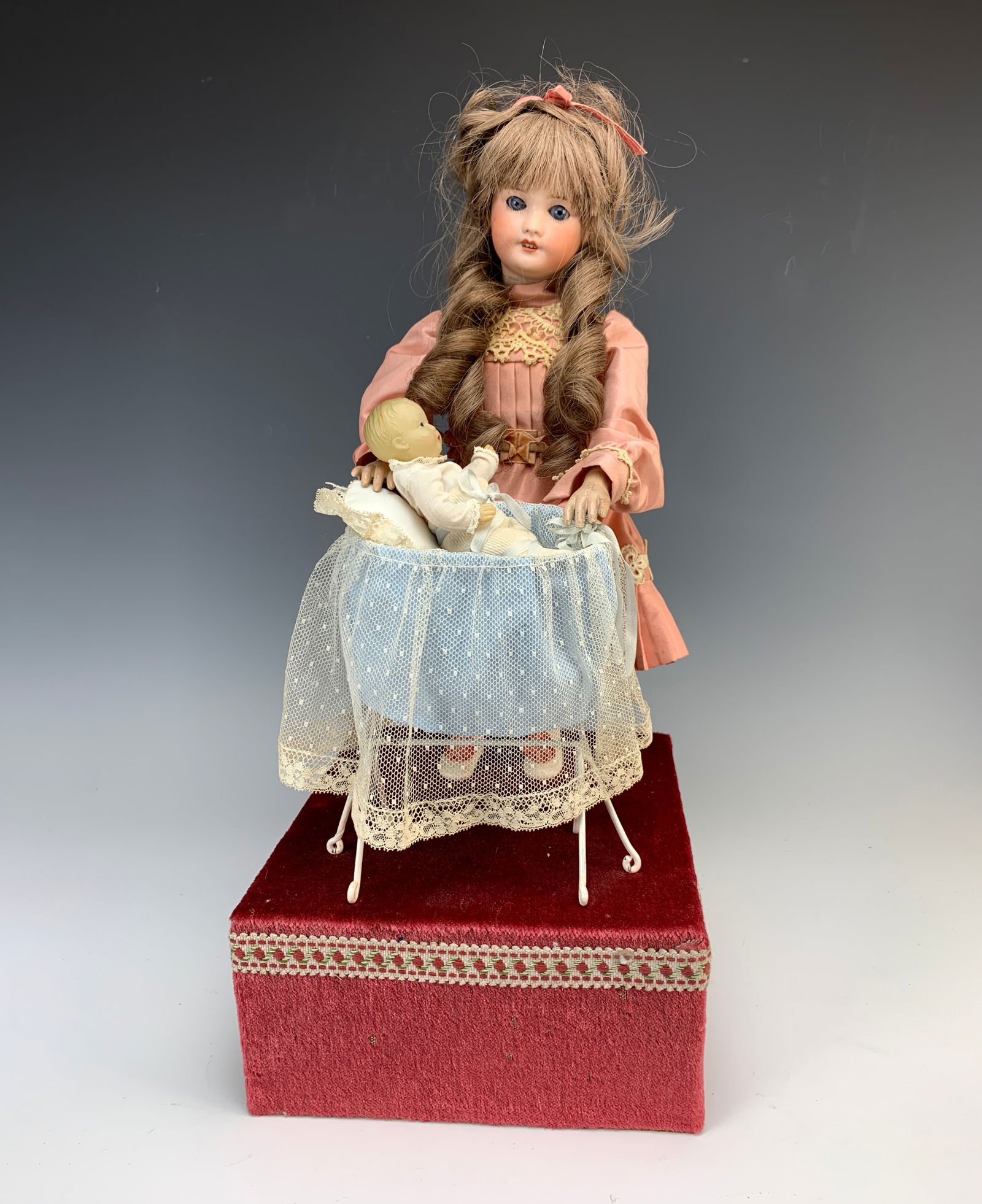 SFBJ Bisque Head Doll Automaton "Rocking Baby": Wonderful signed S.F.B.J. bisque head doll wearing pink and white lace dress, marked "S.F.B.J. France #301 Paris". With electric mechanism, when plugged in she rocks the cradle to and fro, the baby is