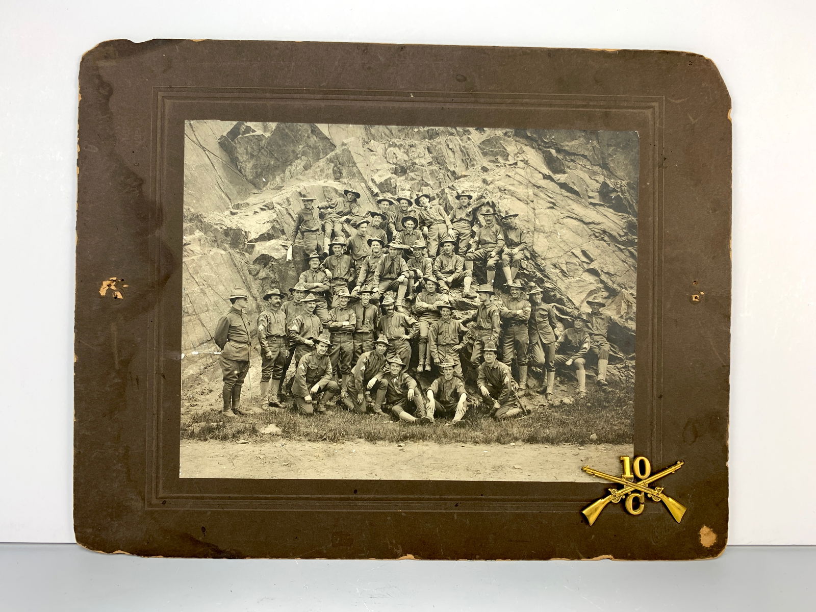 1905 Photograph, 10th Infantry Mountain Division: Large photo from 1905 depicting a group of soldiers from the 10th Infantry Mountain Division. It comes with a brass infantry badge of crossed swords with "10" in the center. 9.5" wide x 7.5" tall (act