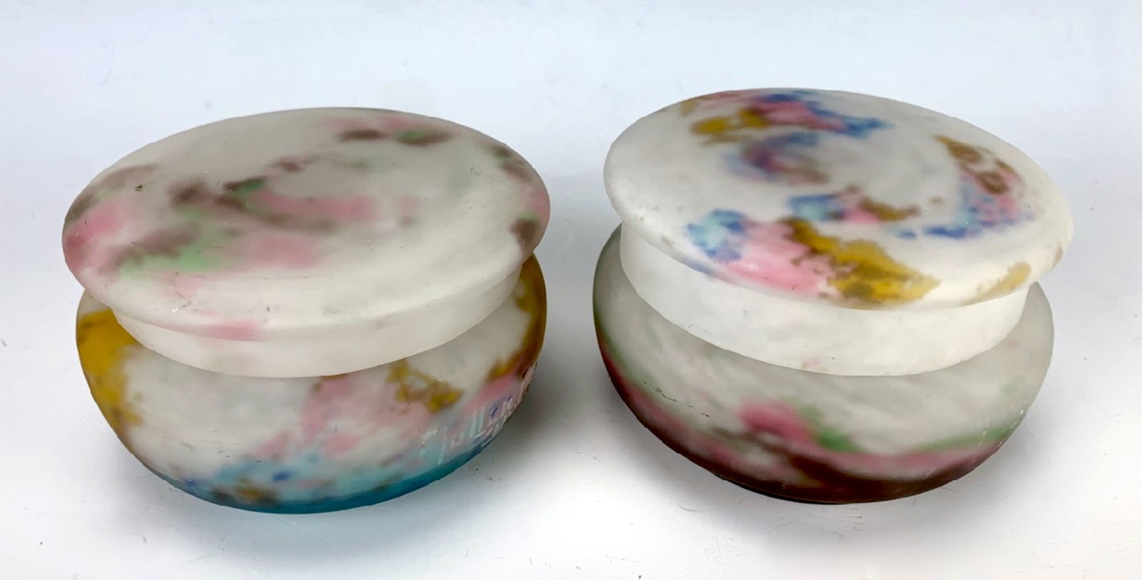 Pair Signed Muller Freres Luneville Powder Jars: Circa 1930, having a matched pair of mottled glass covered powder jars in colors of blue, pink and amber against a white frosted body, each signed "Muller Freres, Luneville", one slightly taller than