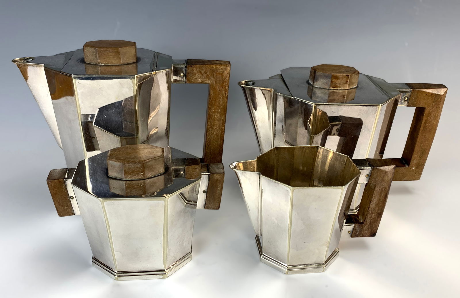French Art Deco Silverplate Tea Set c.1930's: Having a four-piece Art Deco tea set consisting of a coffee pot, teapot, creamer, and sugar, with handles and lids. Marked with numbers. Size: 6 1/8" tallest. Condition: Good, with normal wear from ag