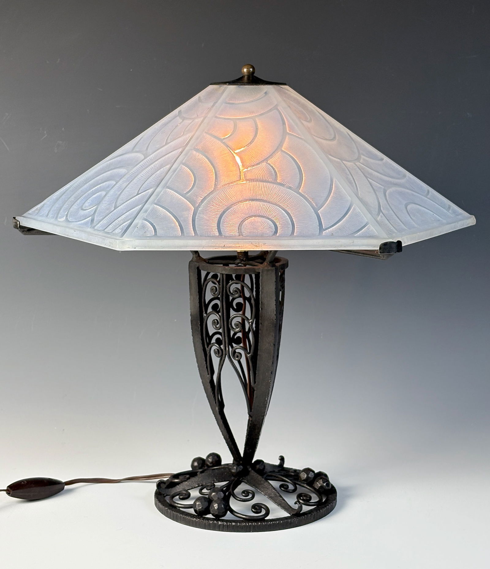 Pierre d' Avesn Art Deco Lamp: c.1920, Pierre d'Avesn (France 1901-1984) a wrought iron base with scrolling openwork supporting a six sided white opalescent satin glass shade with circular designs, signed "P.D' Avesn France", good