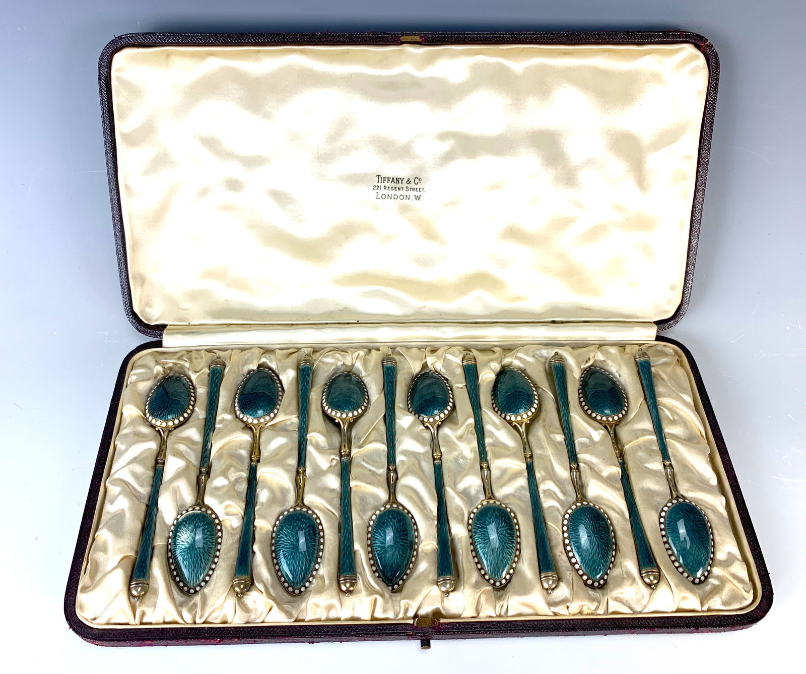 David Anderson / Tiffany & Co Enamel Spoon Set: Fabulous set of 12 sterling silver and enamel demitasse spoons in a fitted box. The box has the mark of Tiffany & Co., 221 Regent Street London, which was the retailer. The spoons are blue basse taill
