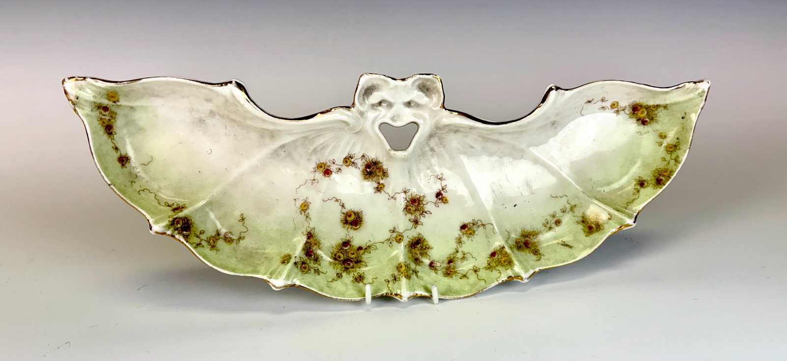 Rare Antique Porcelain Bat Tray: Circa 1900, most likely German, this unique and rare porcelain tray is modeled as a wide spread winged bat with floral decoration accented with gold accents, not signed. Very good condition, gold rim