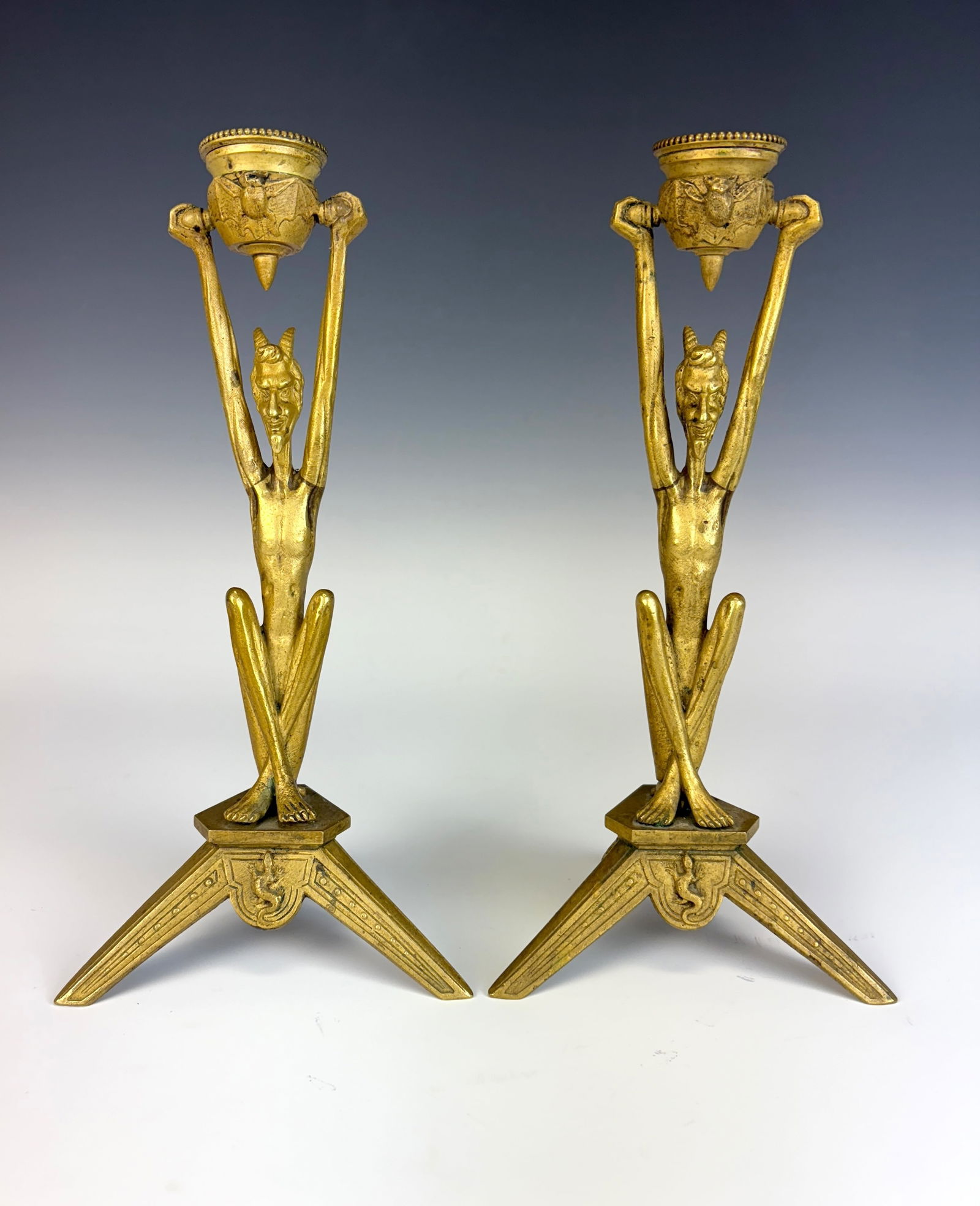 Rare Antique Gilt Bronze Devil Candlesticks Sgd: Rare pair of gilt bronze candlesticks each having a seated crossed legged devil figure supporting cauldrons (cups) with raised bat motifs, the devils mounted on turtles, the 3 legged stand detailed wi