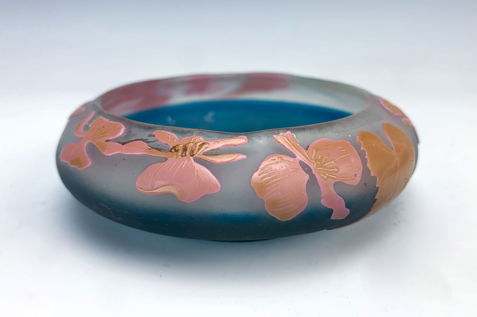 Galle Cameo Glass Small Bowl w Orchids: Circa 1920, A French cameo art glass glass bowl signed Galle with star. Having a blue body on the lower half and pink raised cameo orchids on top over a white frosted body. Very good condition. 1.25"